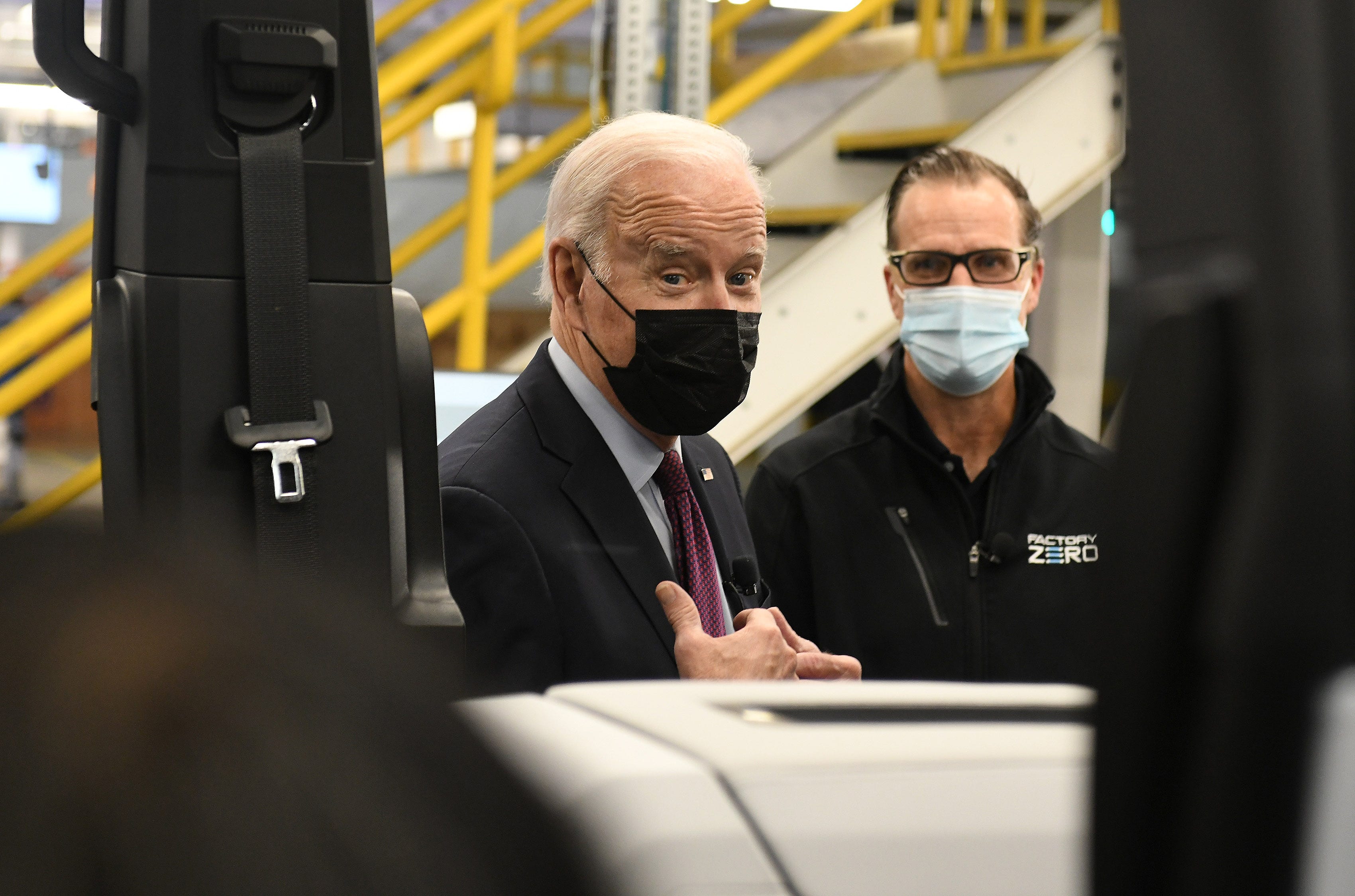 President Joe Biden talks about what he is seeing with plant director Jim Quick, right, at the General Motors Factory ZERO.