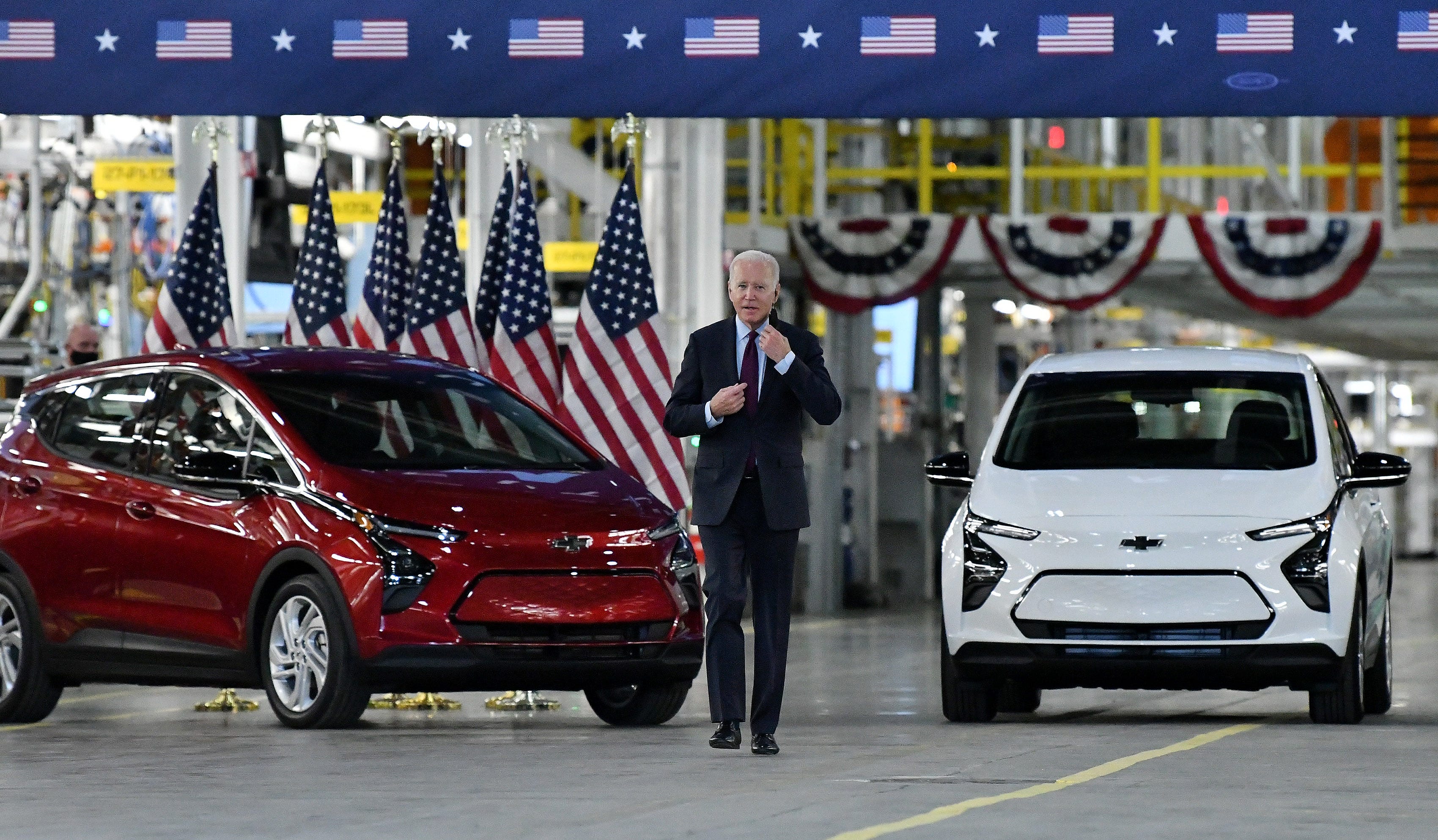President Joe Biden takes off his mask as he heads for the podium to speak at the General Motors Factory ZERO in Detroit.