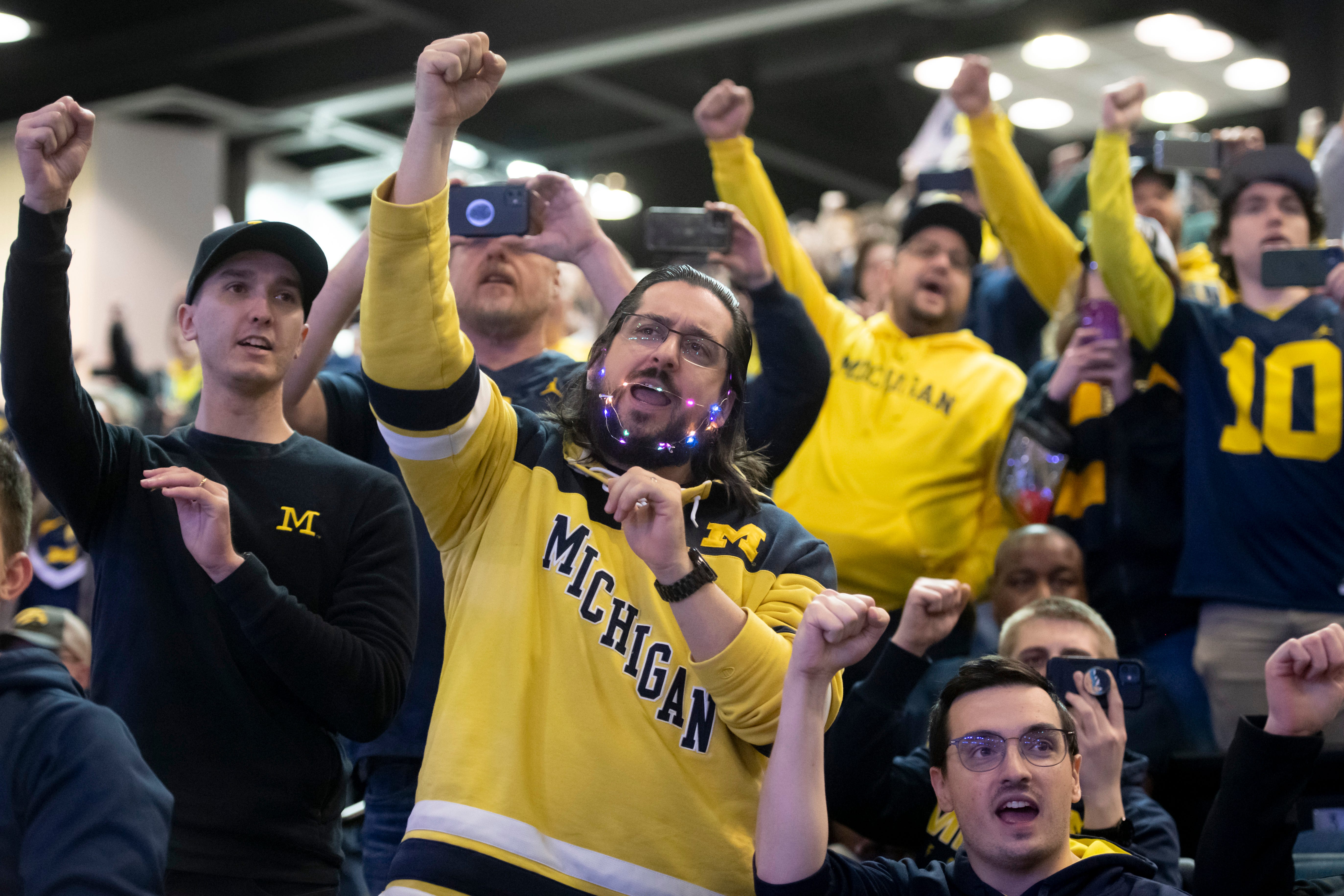 Fans cheer with the Michigan Marching Band at the Fan Fest at the Indiana Convention Center, before the start of the Big Ten championship game.