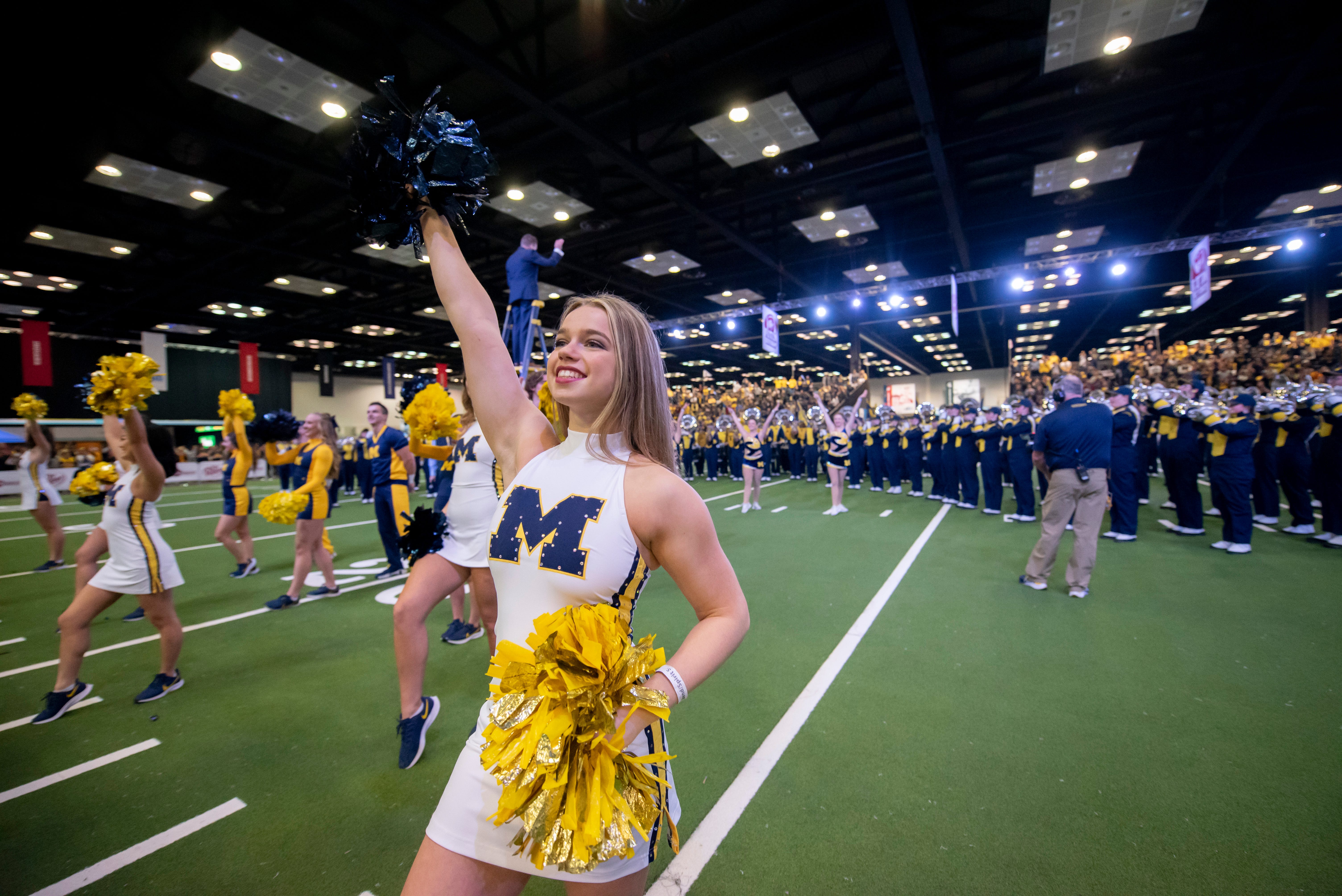 Michigan cheerleaders perform with the Marching Band at the Fan Fest at the Indiana Convention Center, before the start of the Big Ten championship game.