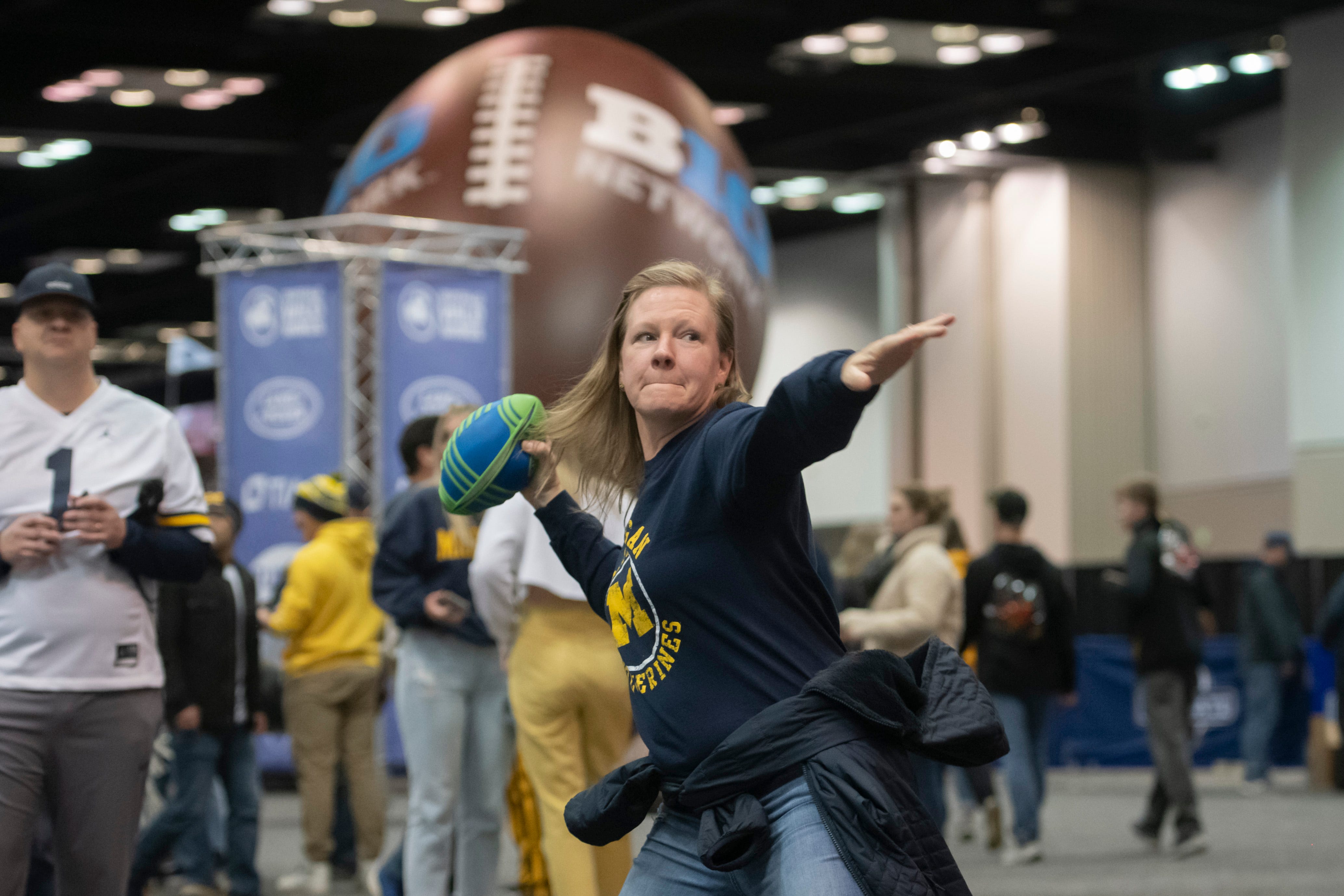 Katie Hausner, of Atlanta, throws a pass at the Fan Fest at the Indiana Convention Center, before the start of the Big Ten championship game.