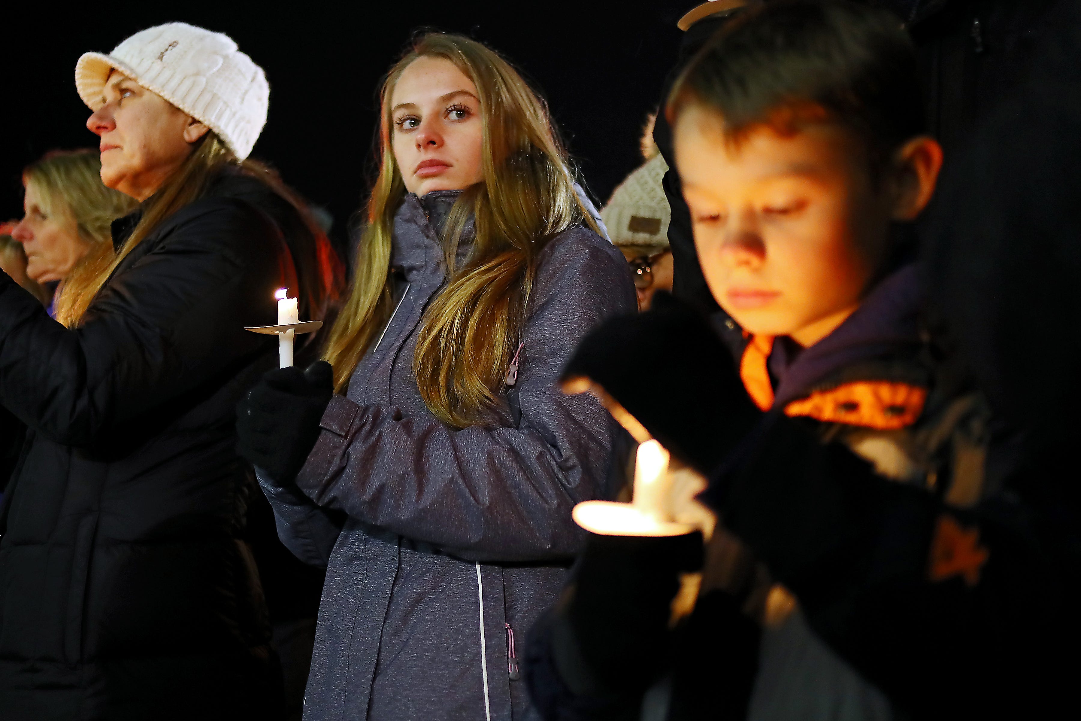 Students take part in a moment of silence during a candlelight vigil on Friday, Dec. 3, 2021 in downtown Oxford in memory of the four Oxford High School students who died in a school shooting earlier this week.