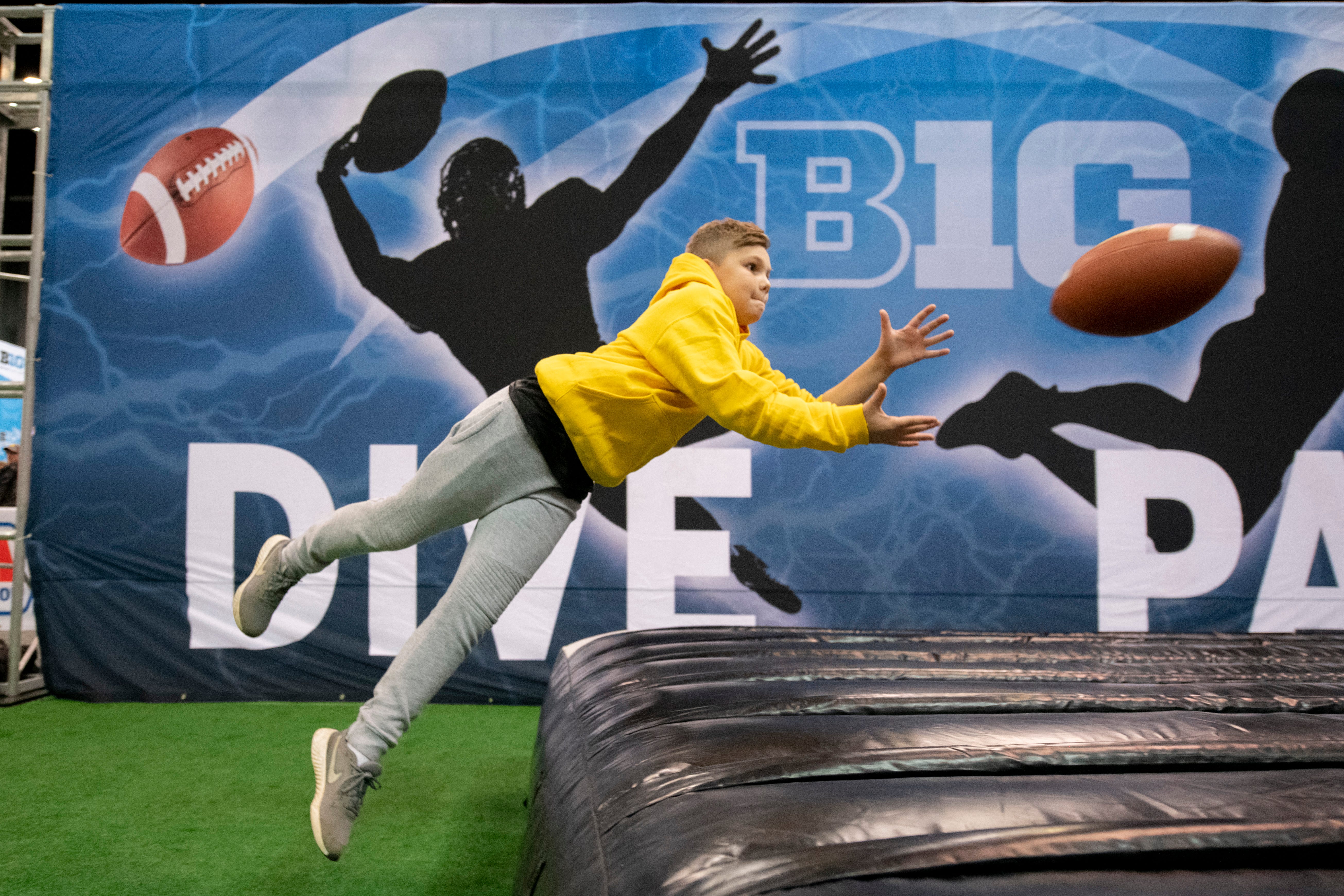 Twelve-year-old Matt Noe, of Crescent Springs, Ky., catches a pass while having fun at the Fan Fest