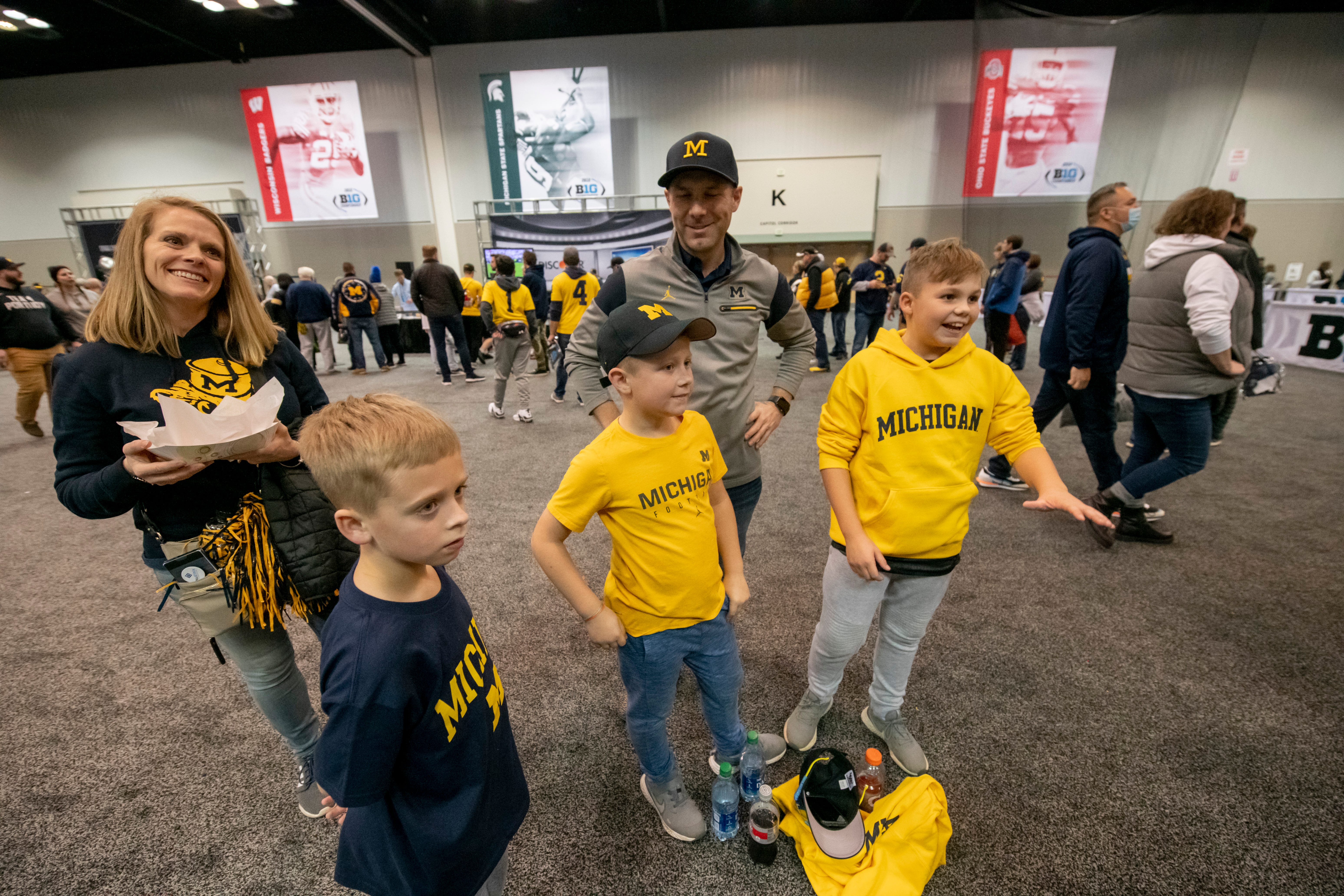 (From left) Stephaney Theobald, her son Maddox, 7, hang out with David Noe, and his two sons Matt, 12, and Charlie, 9, at the Fan Fest at the Indiana Convention Center, before the start of the Big Ten championship game in Indianapolis, December 4, 2021. The family is from Kentucky but David Noe was an Ann Arbor native.
