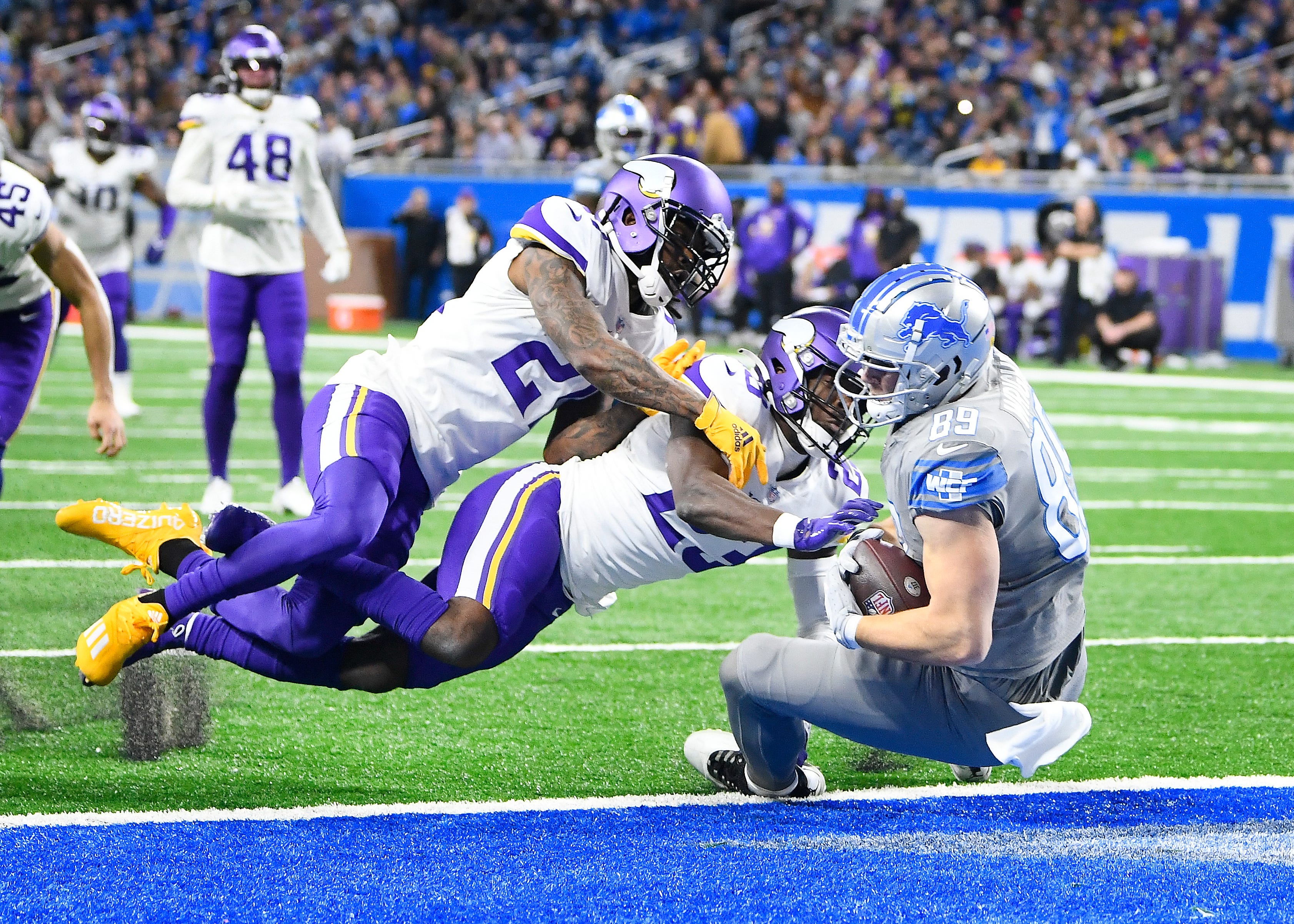 Detroit Lions' Brock Wright goes backwards into the end zone for a touchdown with Minnesota Vikings' Bashaud Breeland and Xavier Woods defending in the second quarter at Ford Field in Detroit, Michigan on December 5, 2021.