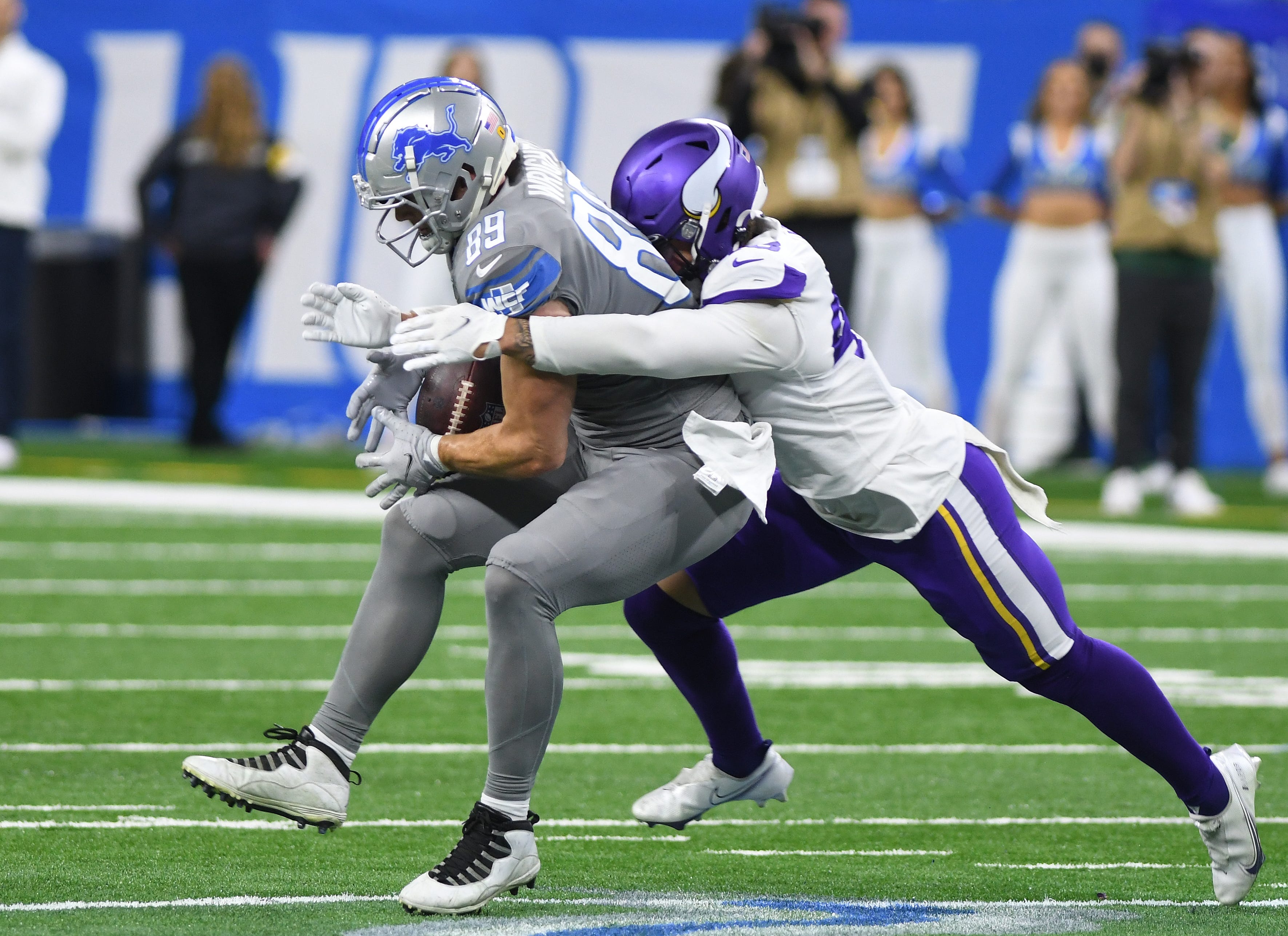 Lions' Brock Wright pulls in a reception with Vikings' Blake Lynch in the second quarter.