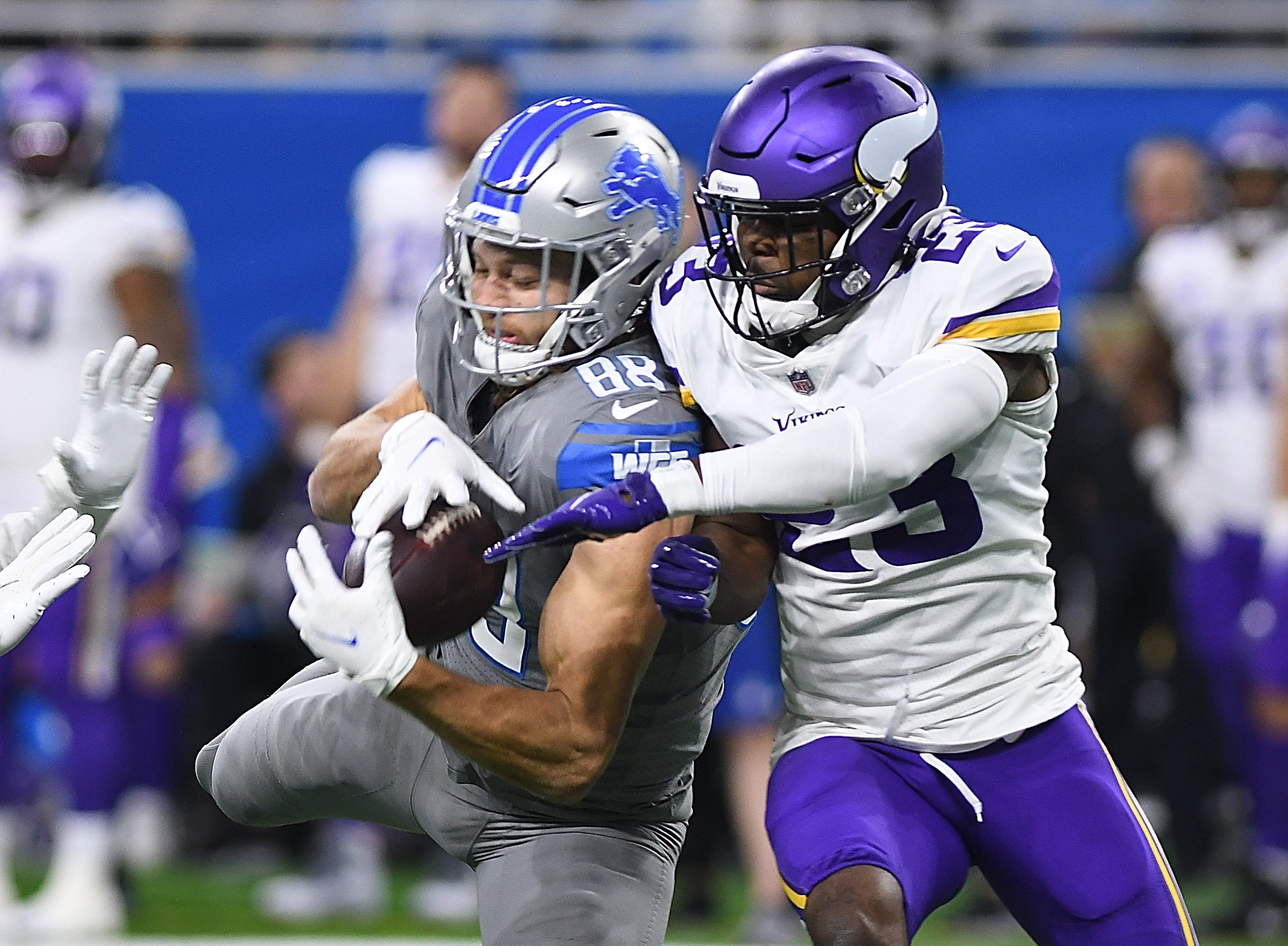 Lions’ T.J. Hockenson pulls in a first down reception in front of Vikings’ Xavier Woods in the second quarter.