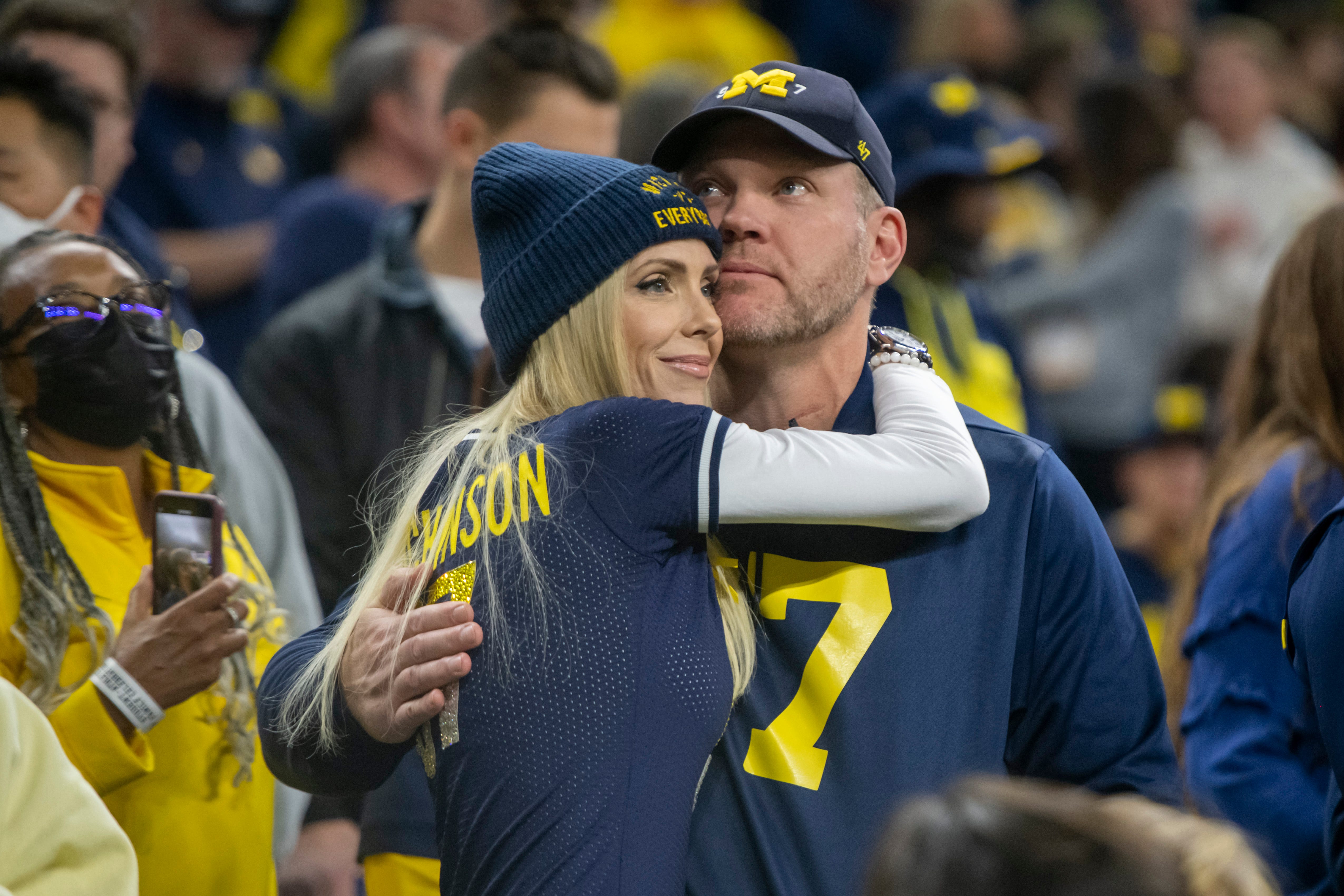 Melissa Hutchinson, left, and her husband Chris, the parents of Michigan defensive end Aidan Hutchinson watch the warmups before the start of the Big Ten championship game.