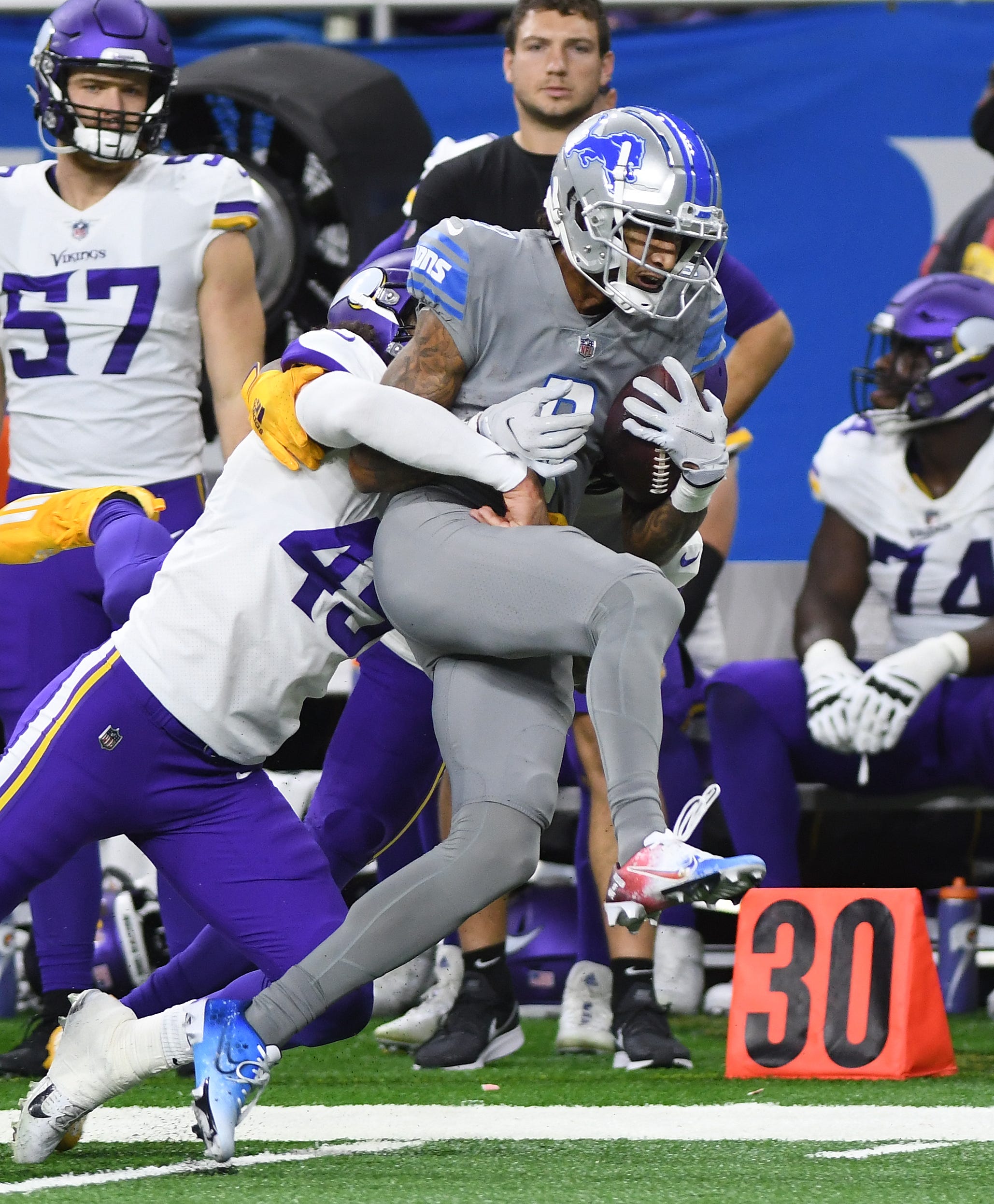 Lions' Josh Reynolds drags Vikings Troy Dye down the sideline after a reception and run in the second quarter.