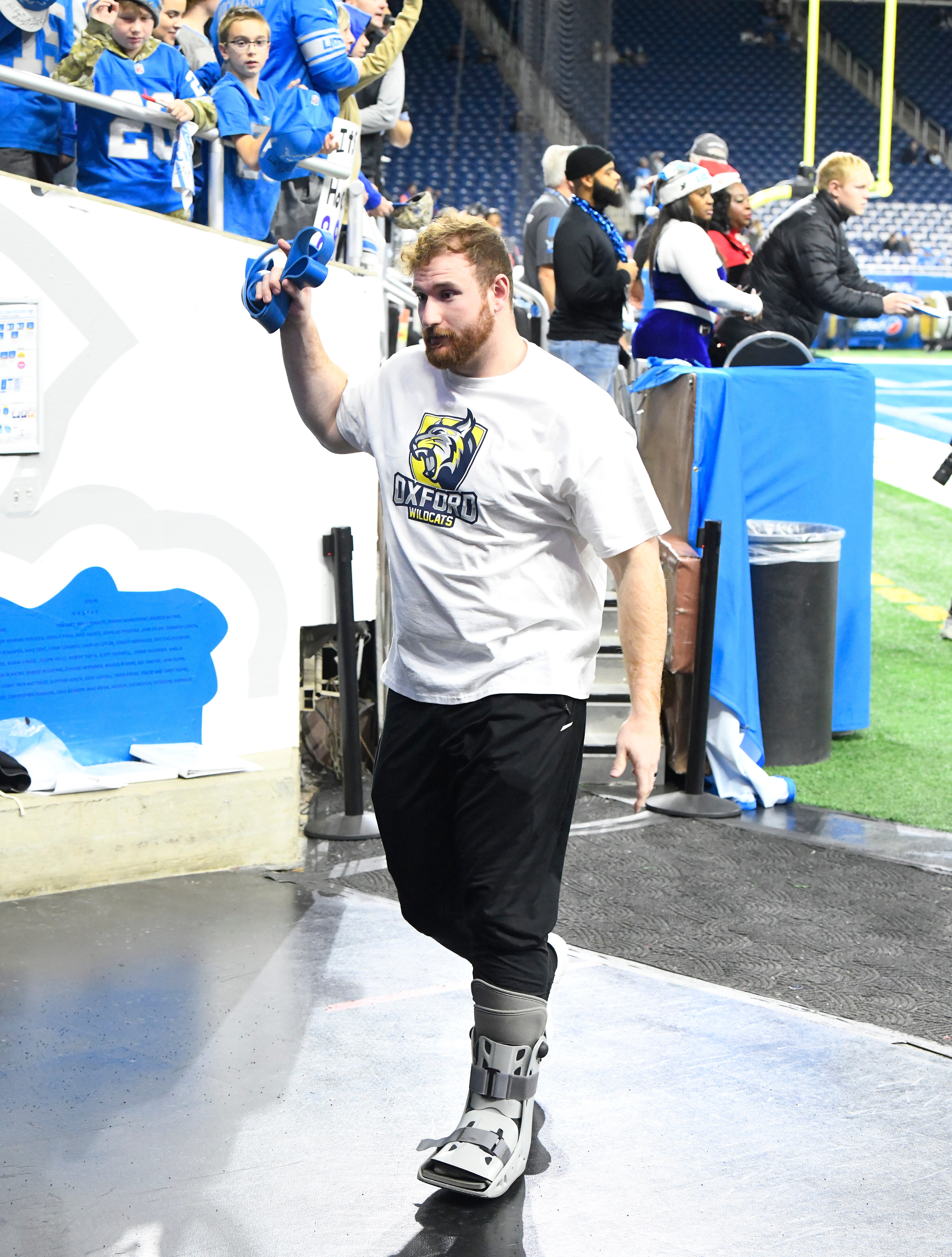 Injured Lions offensive linemen Frank Ragnow, wearing a Oxford Wildcats football t-shirt, goes off the field before game against the Vikings.