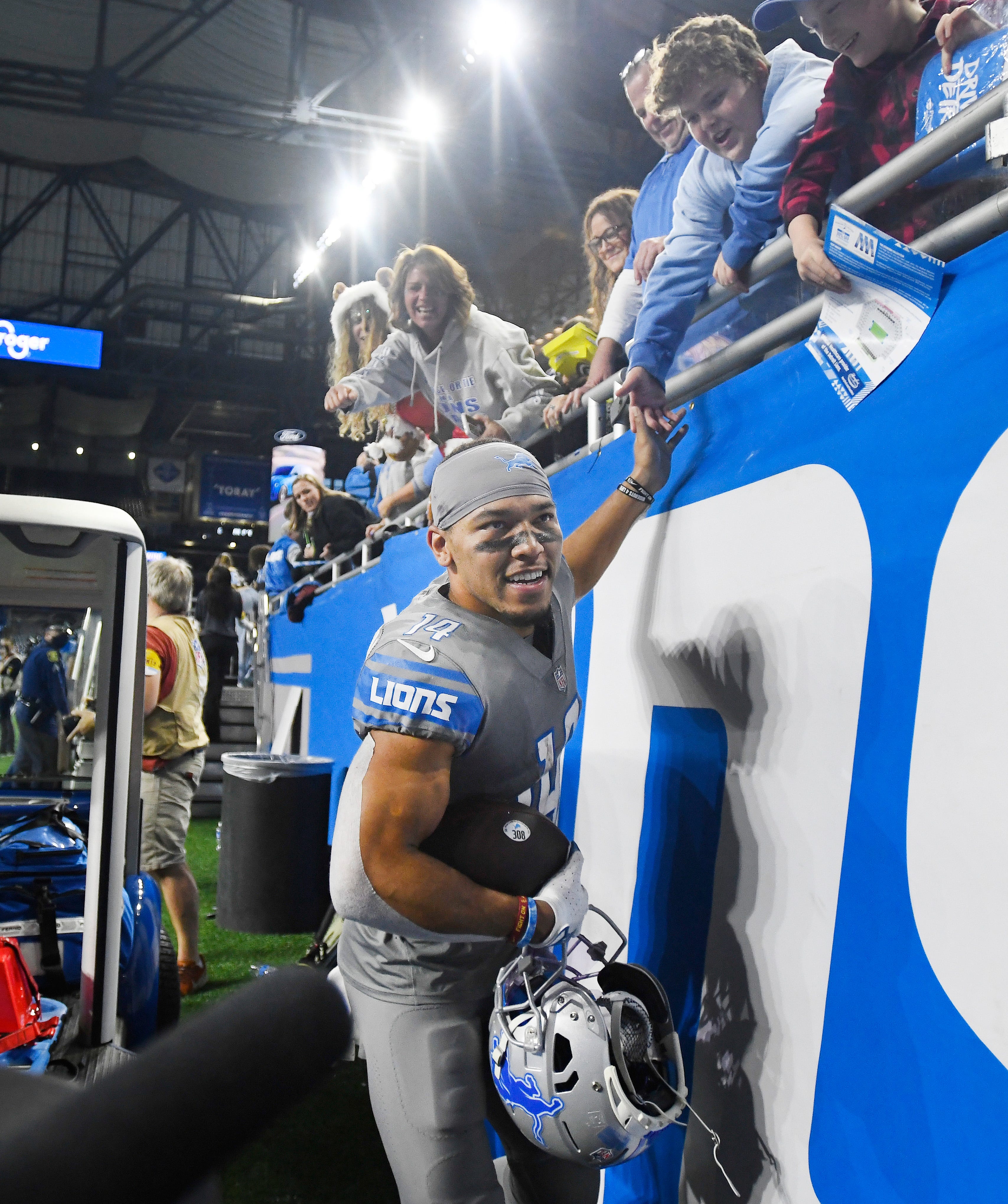 Lions receiver Amon-Ra St. Brown slaps hands with fans as he leaves the field after catching the game winning touchdown, with no time left on the clock, to defeat the Vikings, 29-27.