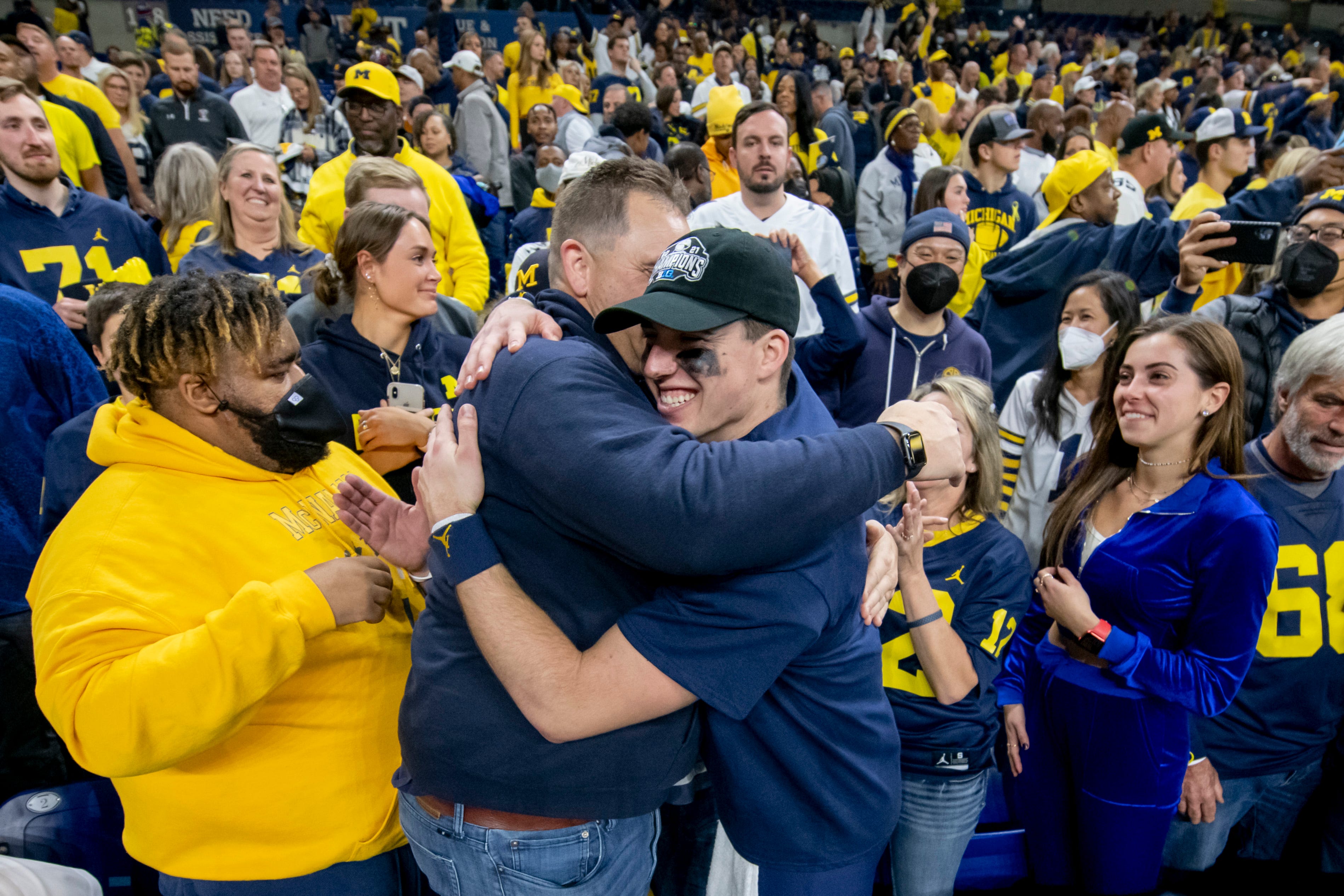 Michigan quarterback Cade McNamara celebrates with his family after the University of Michigan defeated the University of Iowa 42-3 to win the Big Ten championship.