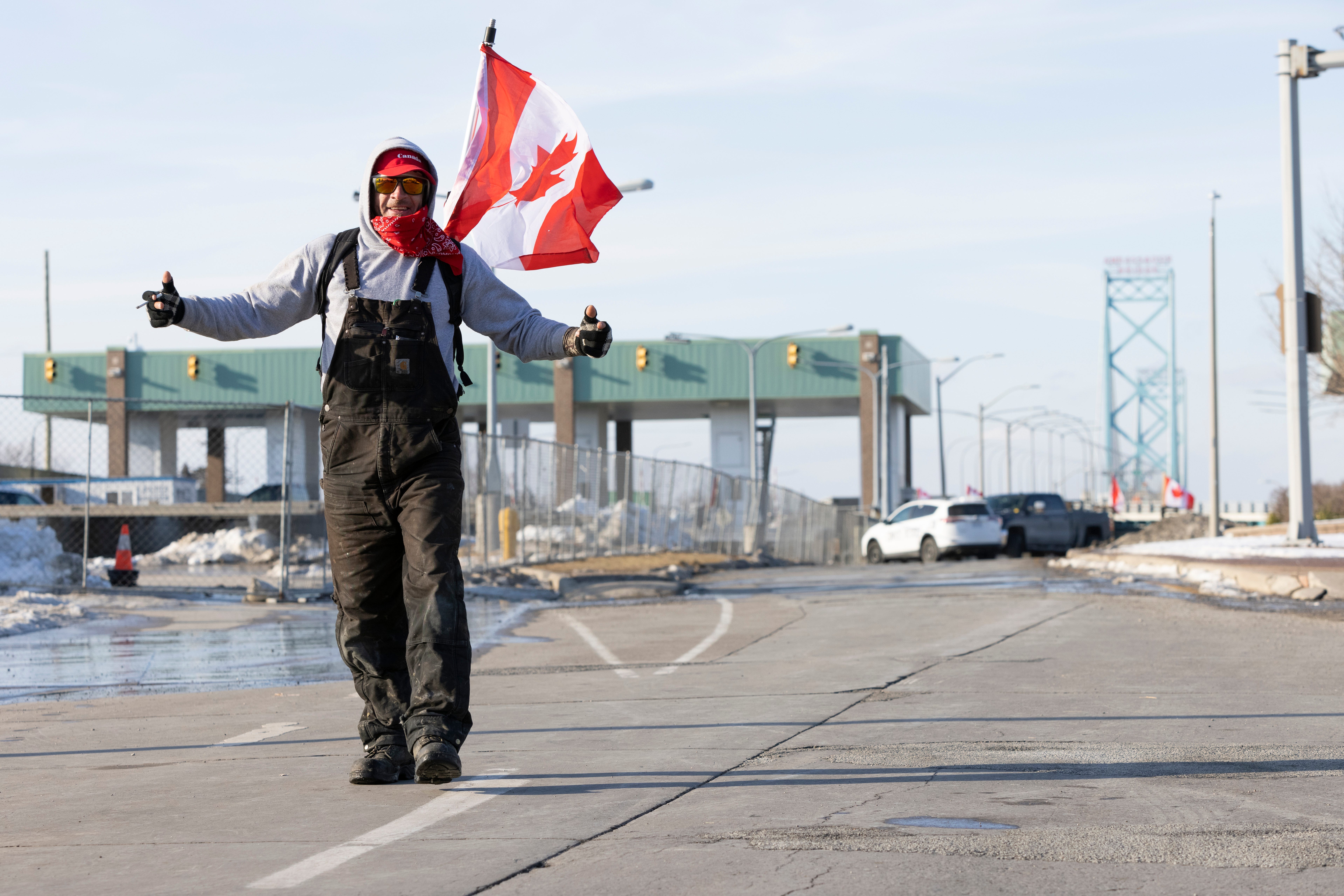 A man takes part in a protest blocking traffic at the Ambassador Bridge, linking Windsor, Ontario and Detroit on Wednesday, Feb. 9, 2022. The demonstration in solidarity with protests in Ottawa against COVID-19 restrictions has blocked traffic into Canada on the Ambassador Bridge linking Windsor and Detroit since Monday and is the the single busiest commercial crossing in North America.