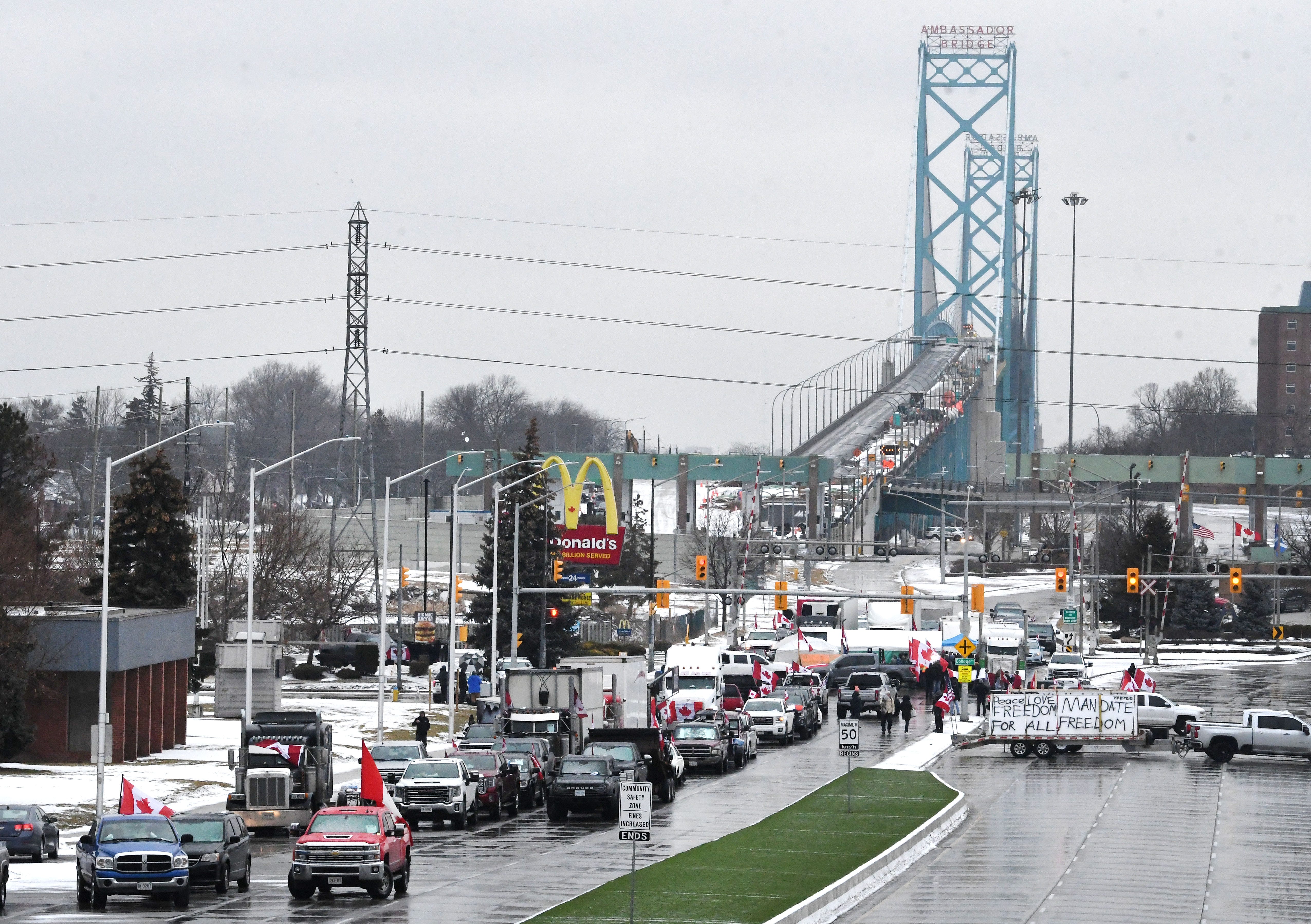 Canadian truckers protest on corner of Huron Church Road and Tecumseh, with the Ambassador Bridge in the background, in Windsor, Canada on February 11, 2022.