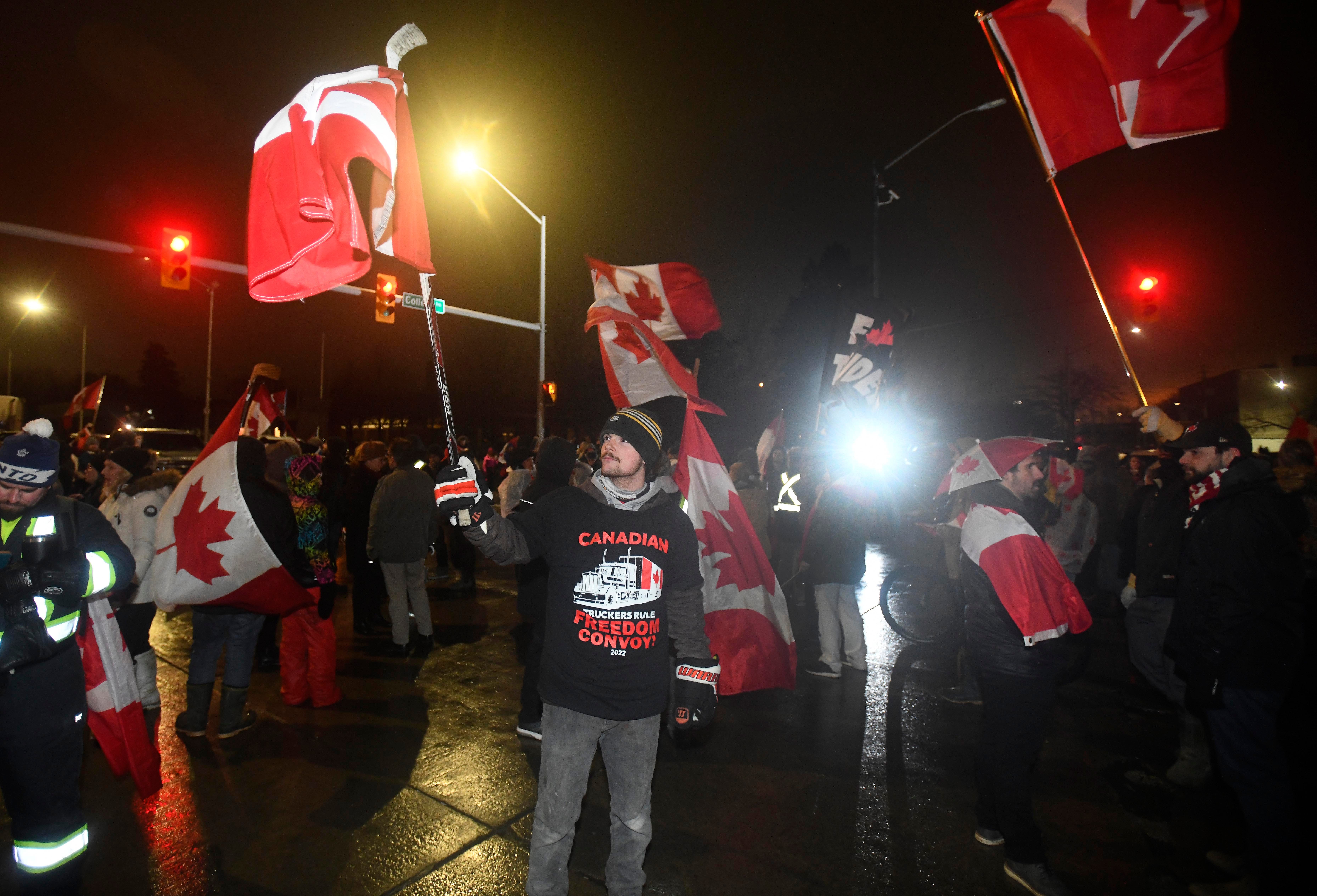 Protesters waves flags in the street in Windsor, Canada on February 11, 2022 during a Canadian Freedom Convoy border blockade Friday night.