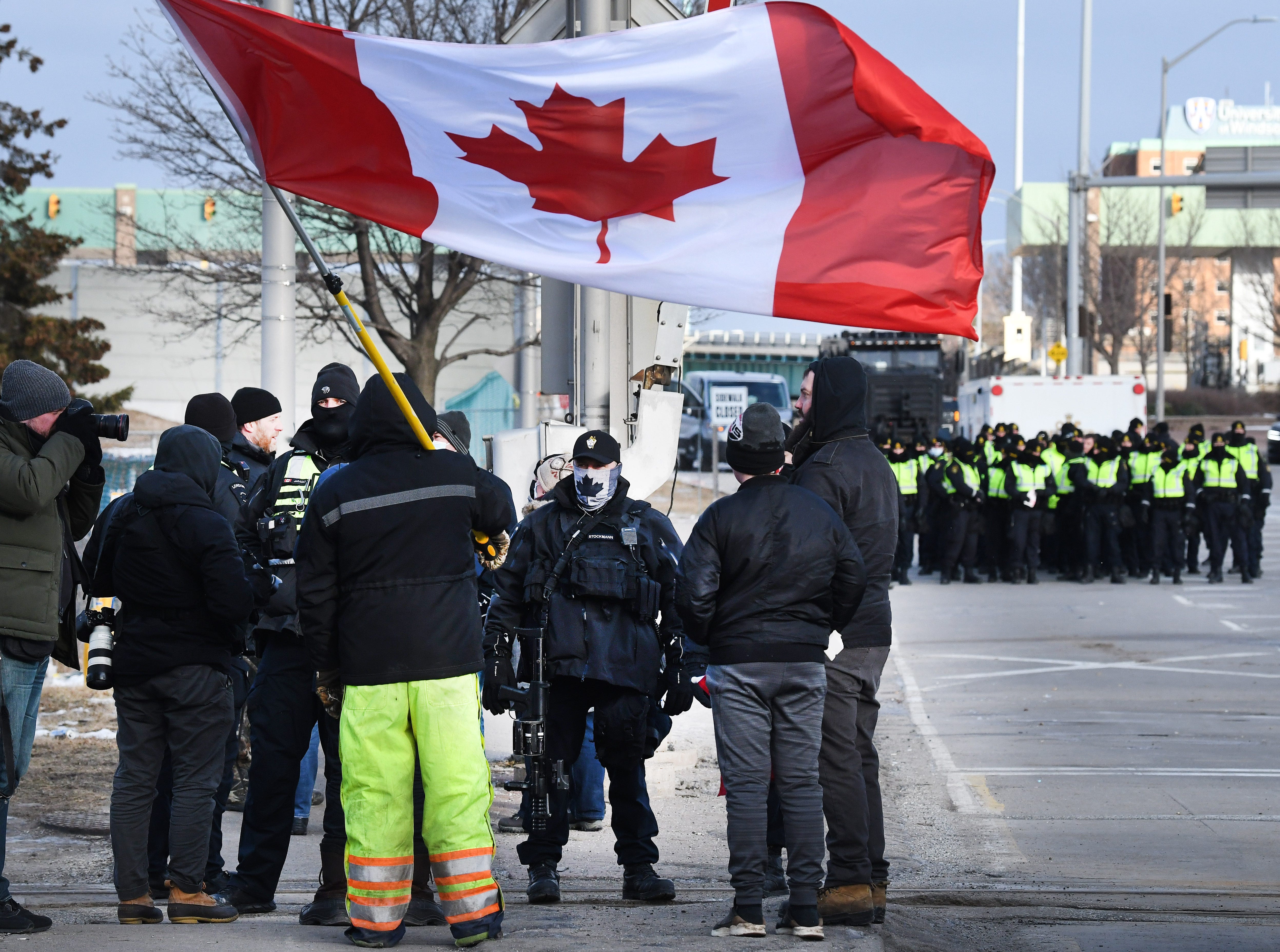 Law enforcement officers move into position to clear a blocked road in Windsor, Canada, on February 12, 2022.