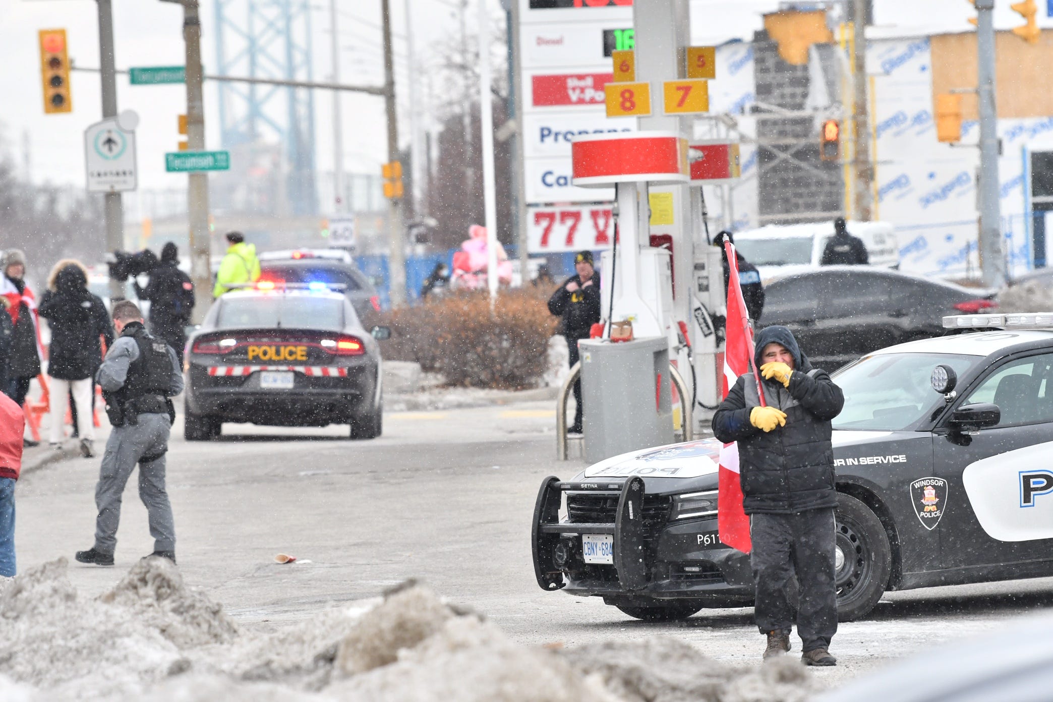 Windsor and London Police officers inform people parked in a shopping area parking lot on Huron Church Road that they cannot stay parked unless they are using the businesses and will be towed. This is not far from Ambassador Bridge in Windsor, Ontario, on Feb. 13, 2022.