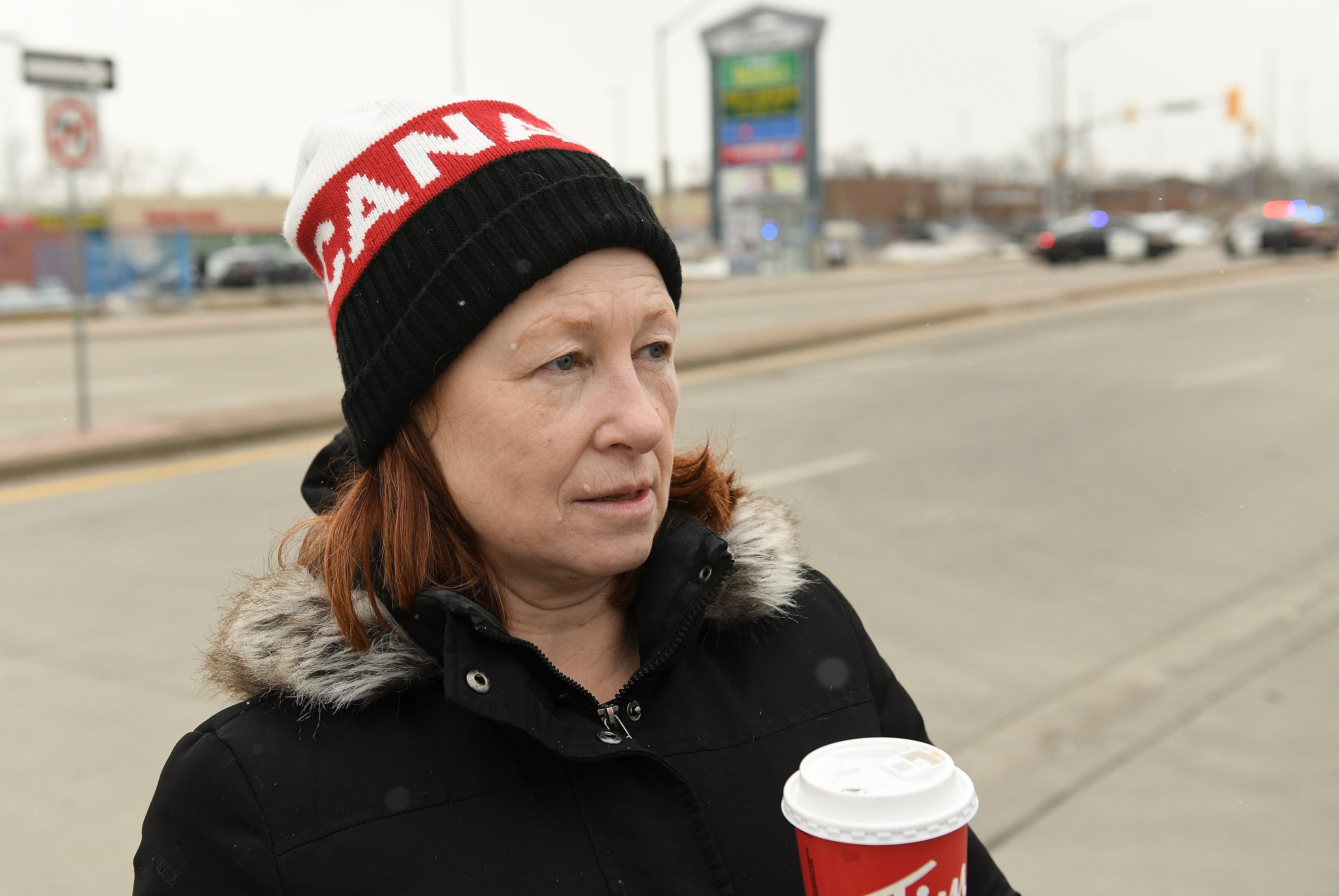 Charlene Renaud, 56, who lives a few blocks from the road that leads to the Ambassador Bridge, talks about her encounter with the police presence as she went for a walk today in Windsor, Ontario, on Feb. 13, 2022.  
(Robin Buckson / The Detroit News)