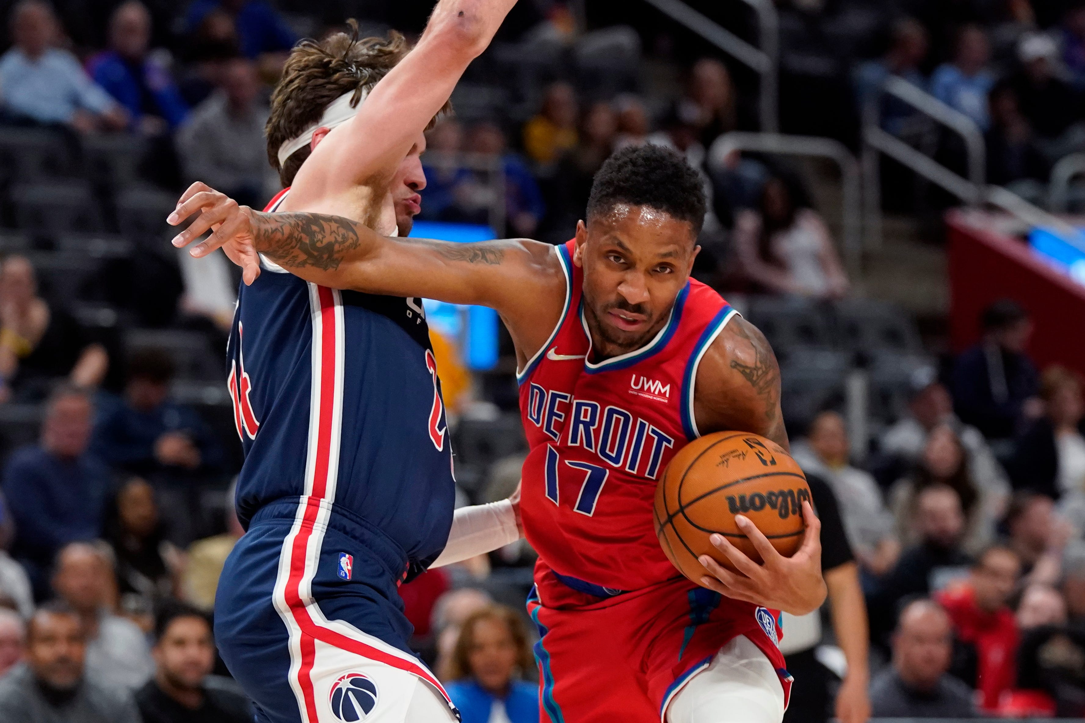 Detroit Pistons guard Rodney McGruder (17) pushes through Washington Wizards forward Corey Kispert during the first half of an NBA basketball game, Friday, March 25, 2022, in Detroit.