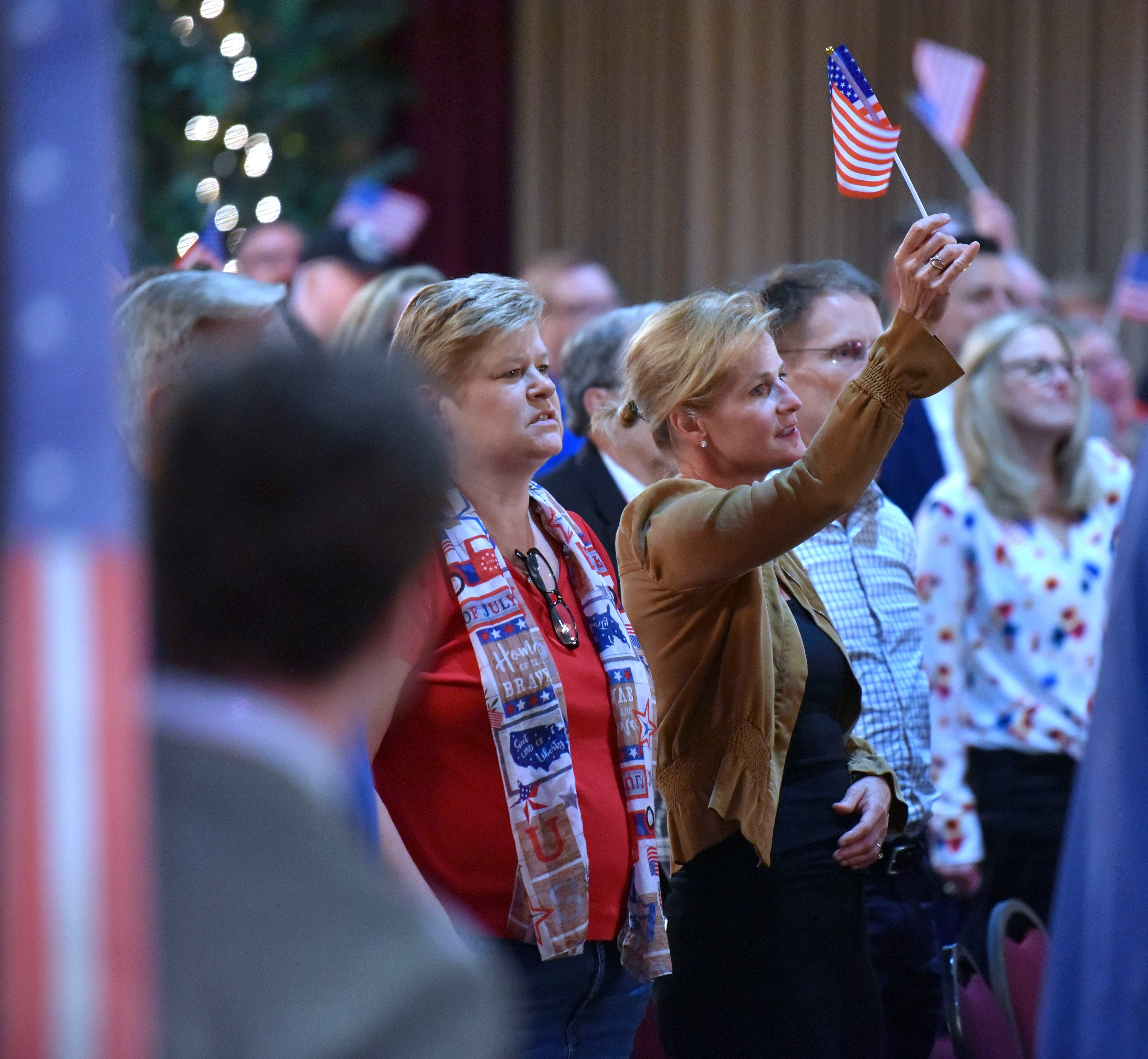 Monica Schafer, of Williamston, and others wave flags before the debate, Thursday night, May 12, 2022.