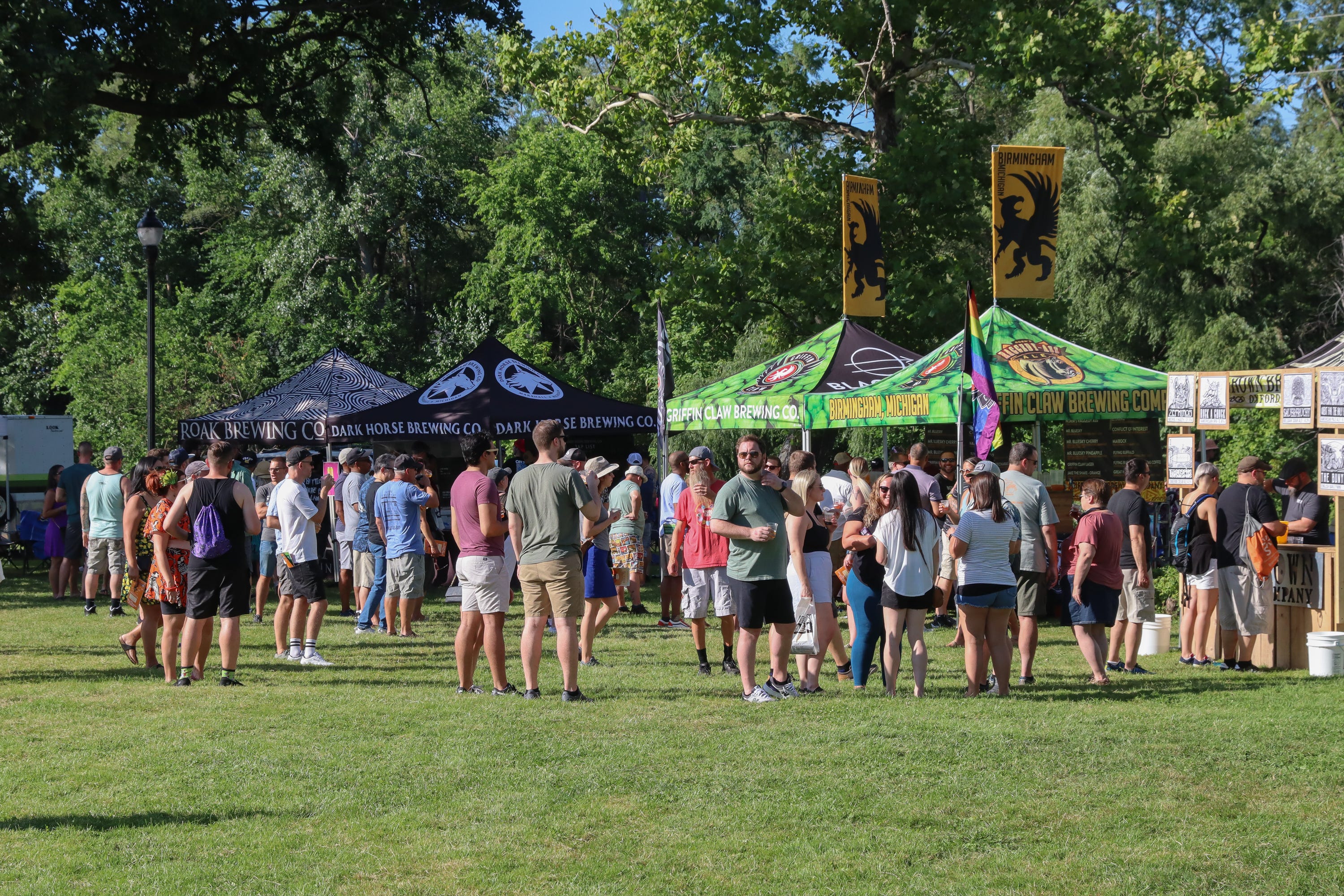 Beer fans line up at a series of brewer tents along the Huron River in Ypsilanti's Riverside Park on Friday, July 22, 2022.