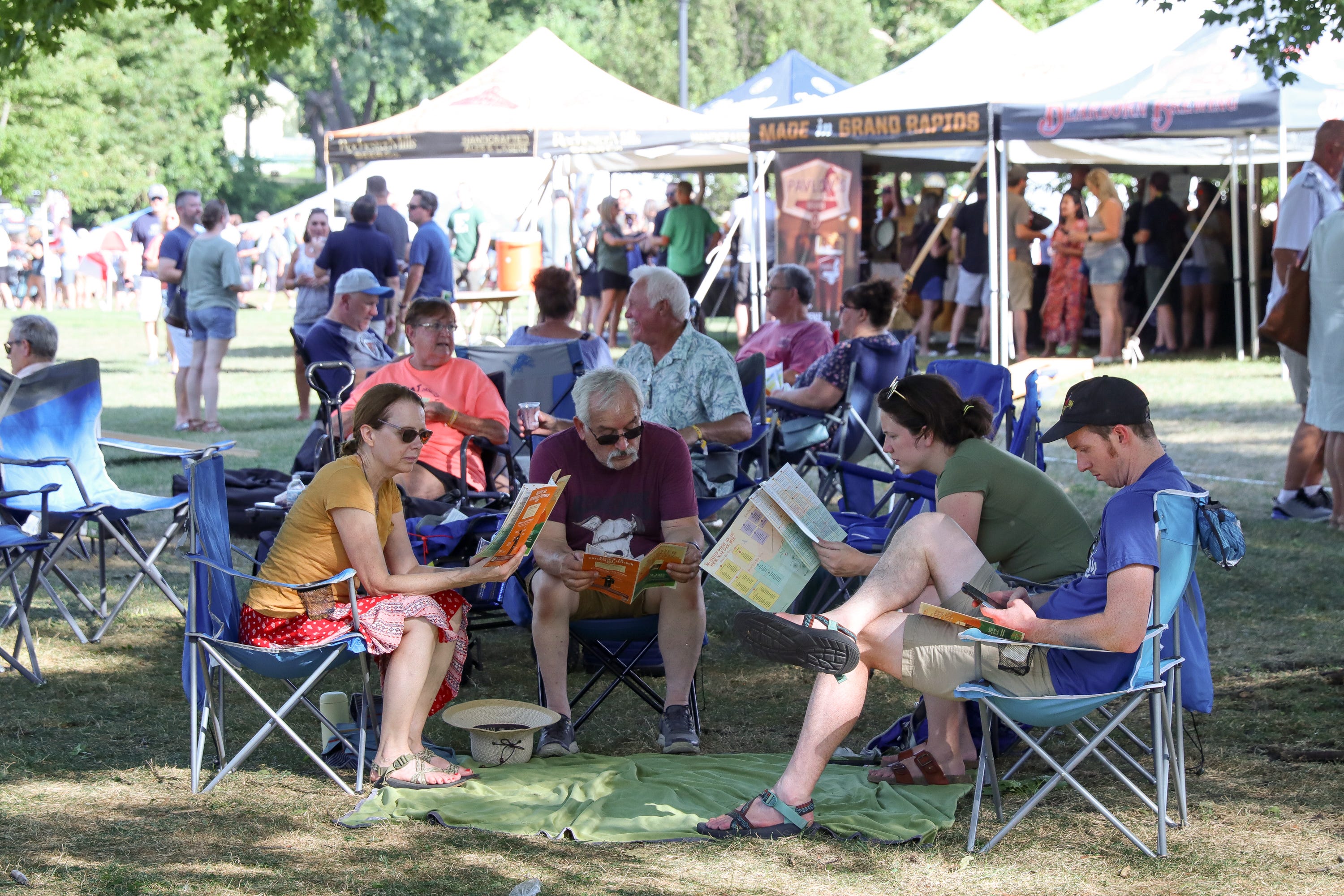 A group of Summer Beer Festival patrons looks over the event program to scout out their next beer choice on Friday, July 22, 2022.