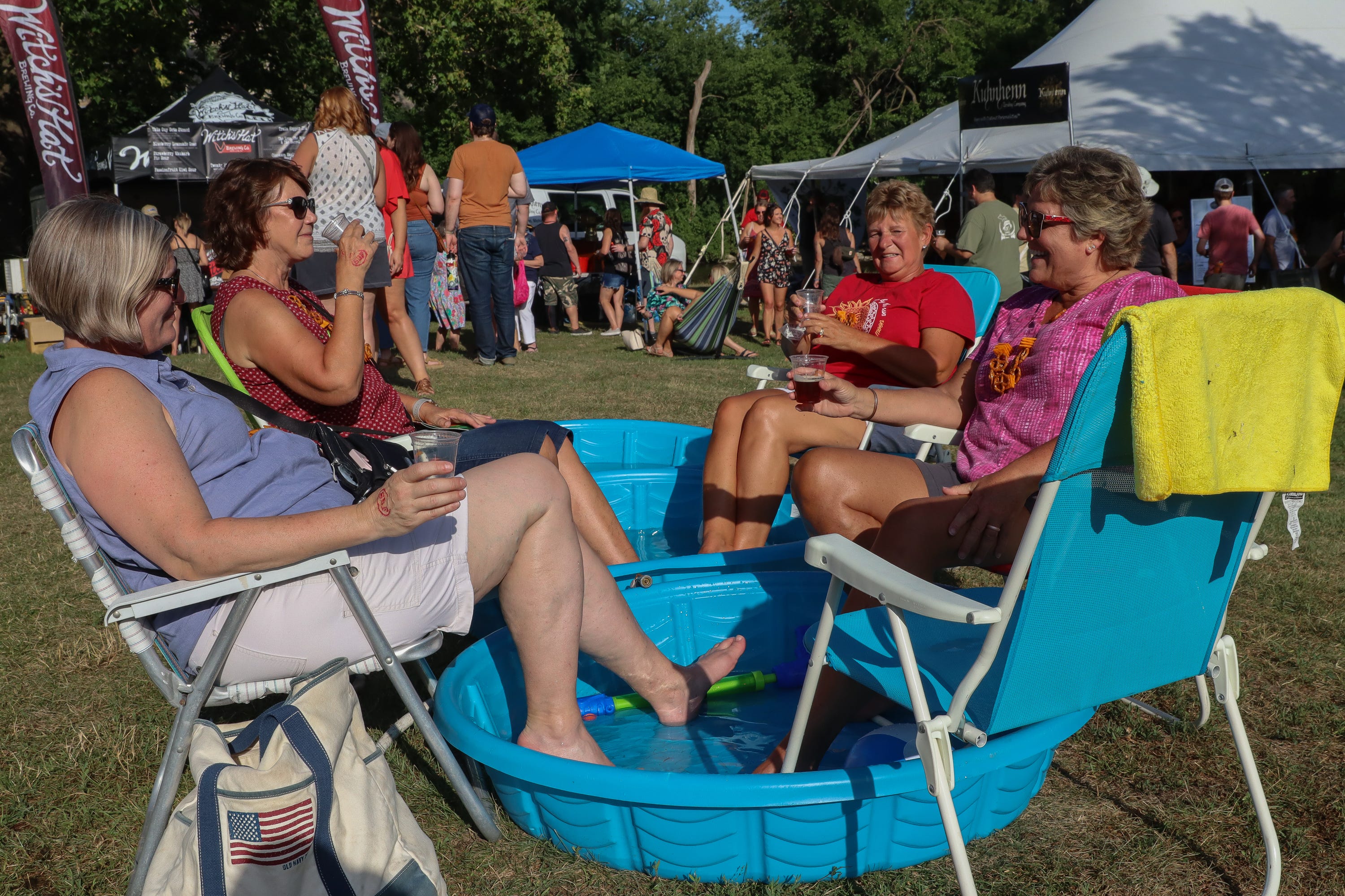 Left to right: Sharon Fries, Mary Spitzley, Marianne Turner and Connie Poremba, all of Canton, cool their heels at the Michigan Brewers Guild Summer Beer Festival Friday in Ypsilanti's Riverside Park.
