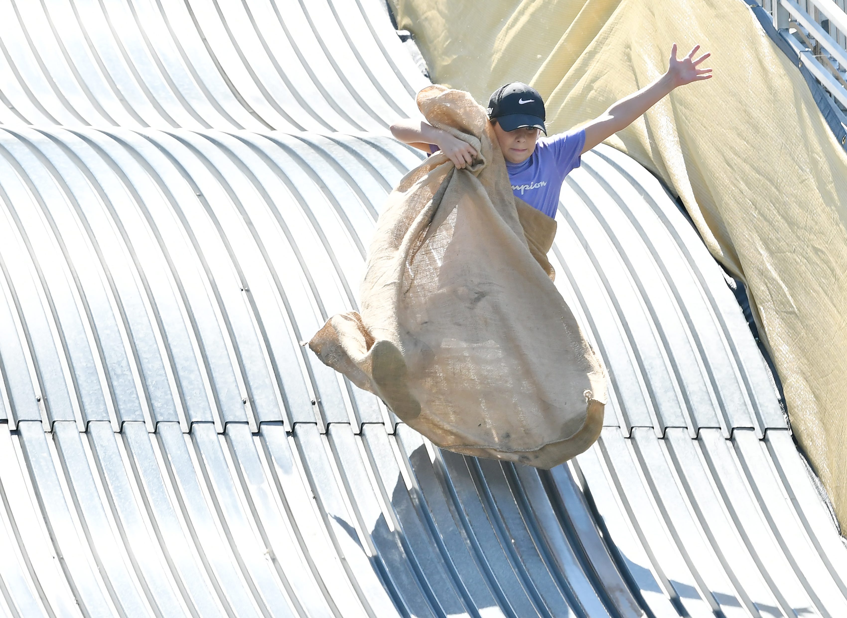Bianca Whitney, 10, of Royal Oak is airborne going down the giant slide on Belle Isle in Detroit on Aug. 19, 2022.