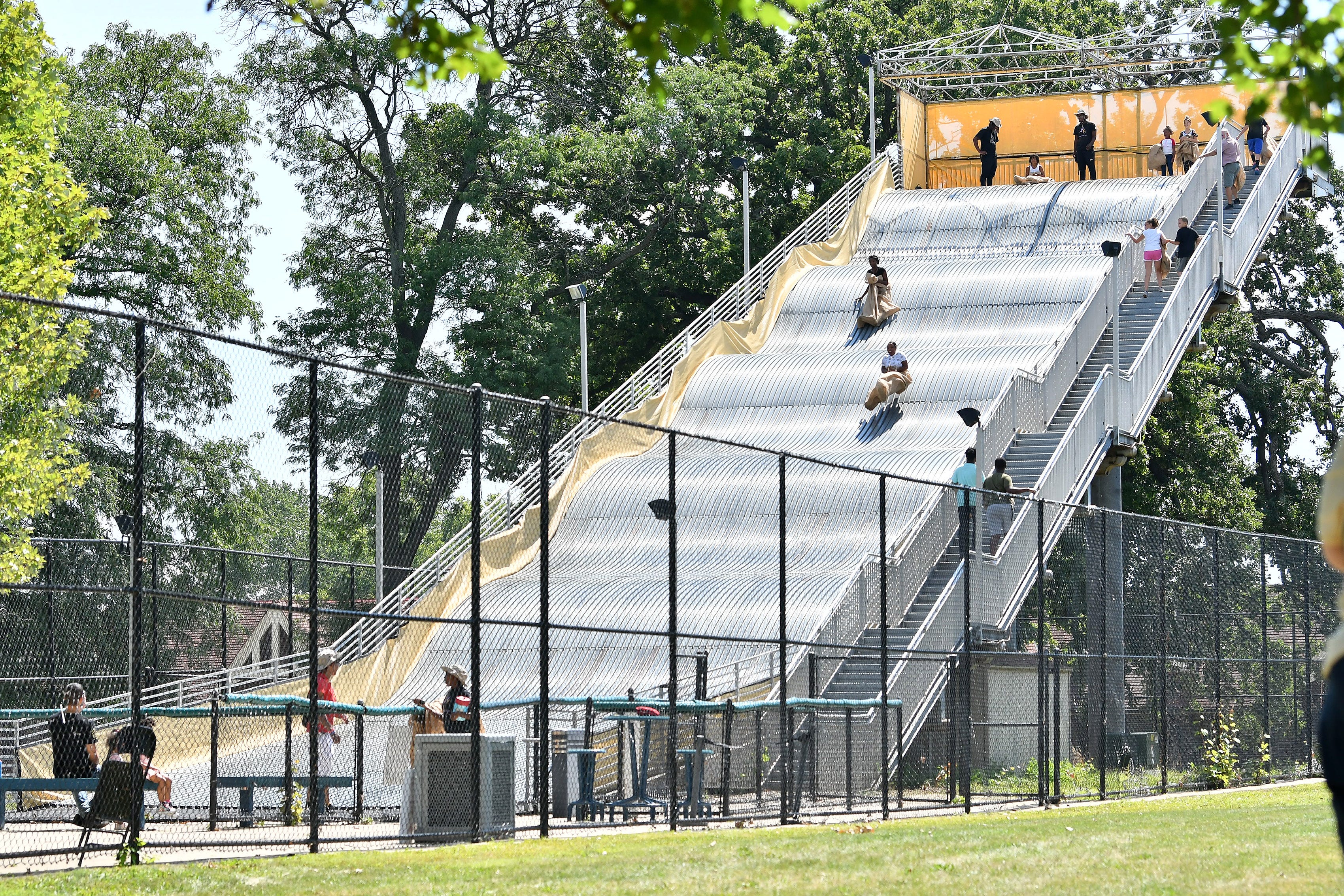People go down the giant slide on Belle Isle in Detroit on Aug. 19, 2022.