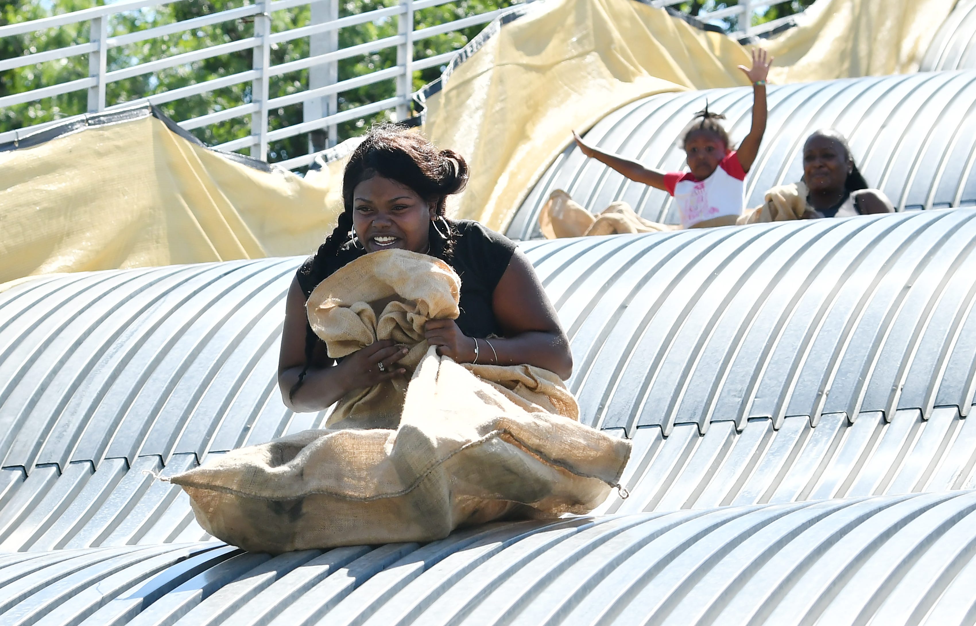 Shatarah Martin, 30, of Detroit goes down the giant slide on Belle Isle in Detroit on Aug. 19, 2022.
