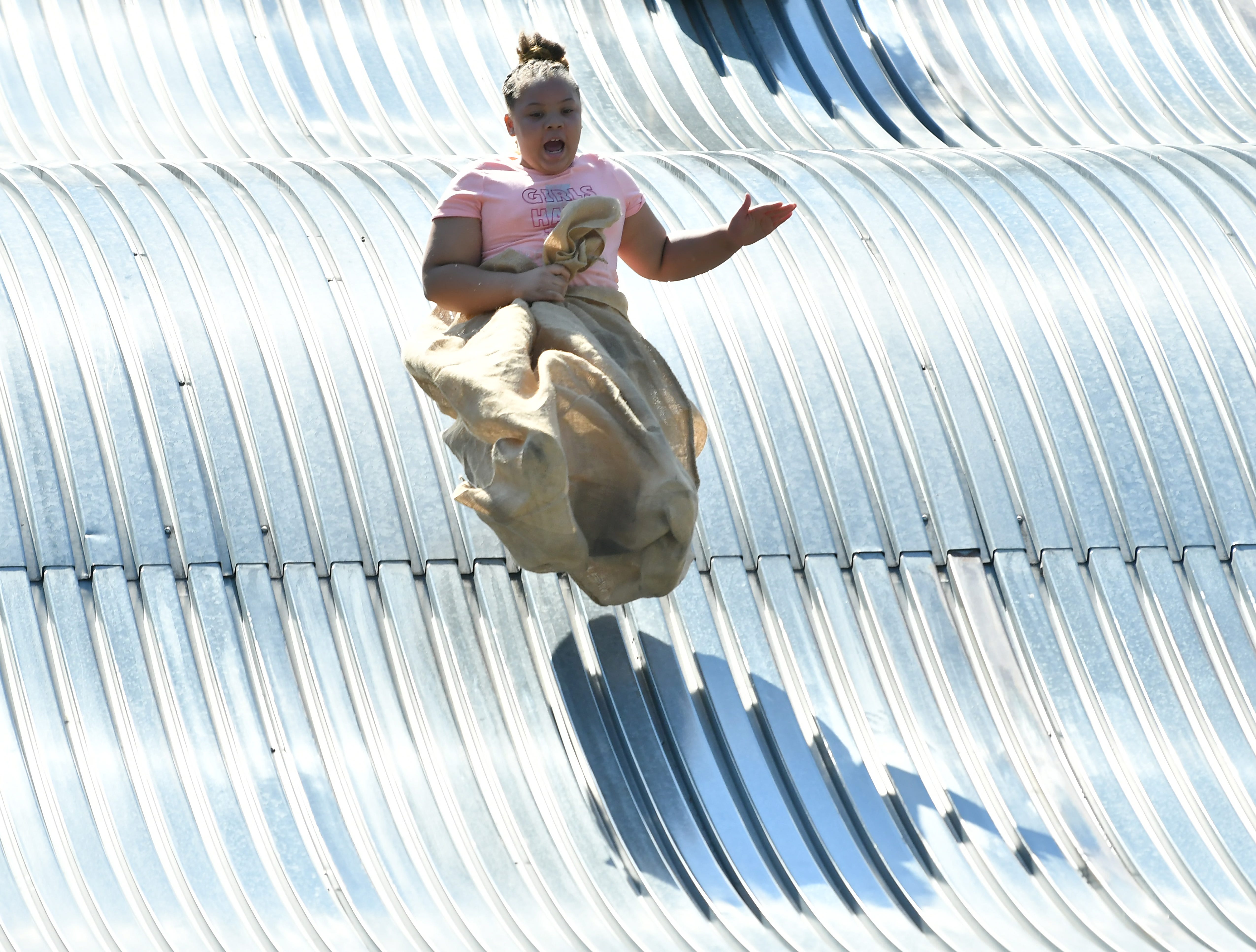 Kasey Chapple, 9, of Warren is airborne going down the giant slide on Belle Isle in Detroit on Aug. 19, 2022.