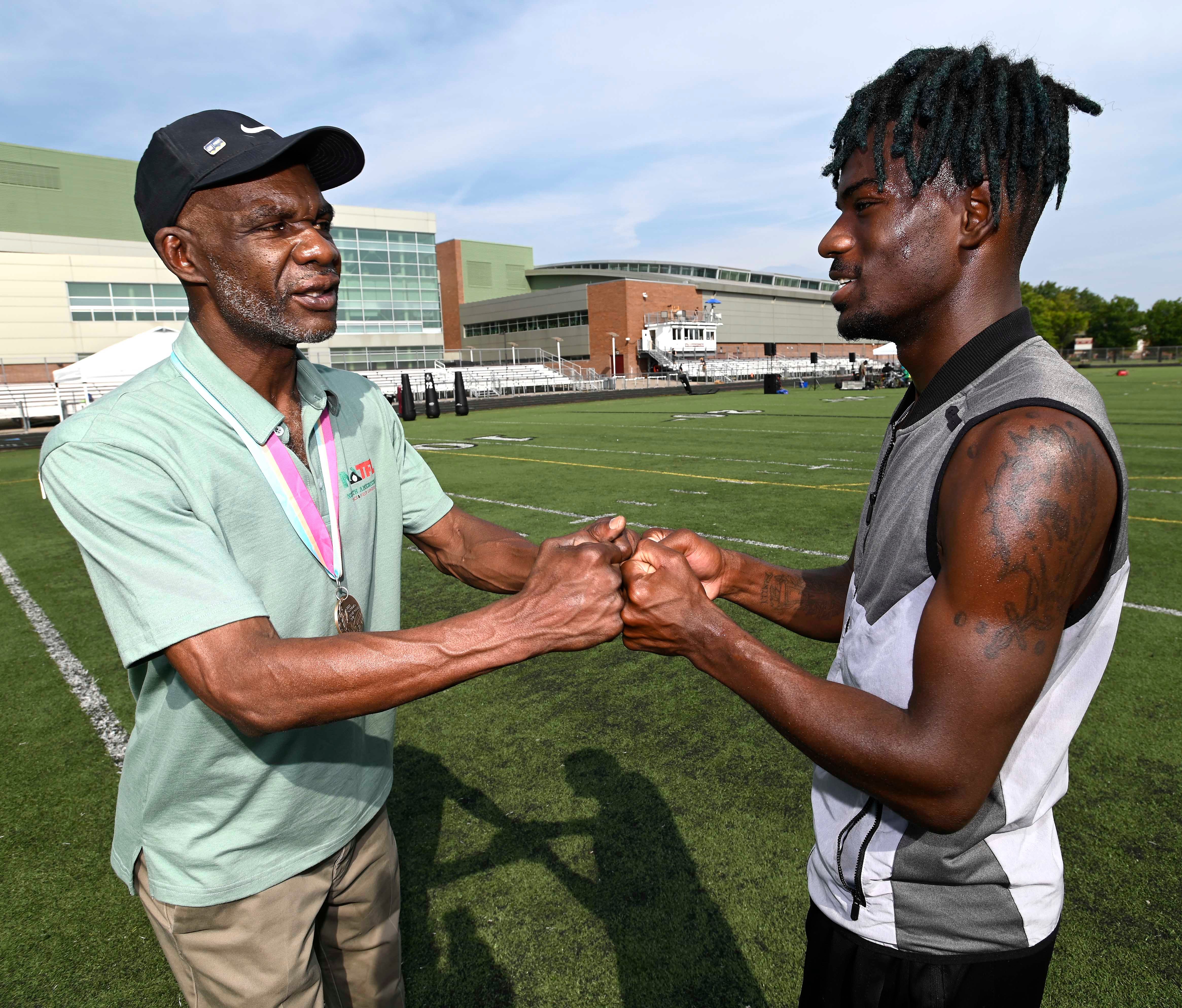 Earl Jones, left, double-fist bumps runner Montel Lewis, 21, of Detroit, on Saturday morning at a meet at Detroit Renaissance. Jones won a bronze medal in the 800-meter run in the 1984 Olympics.
