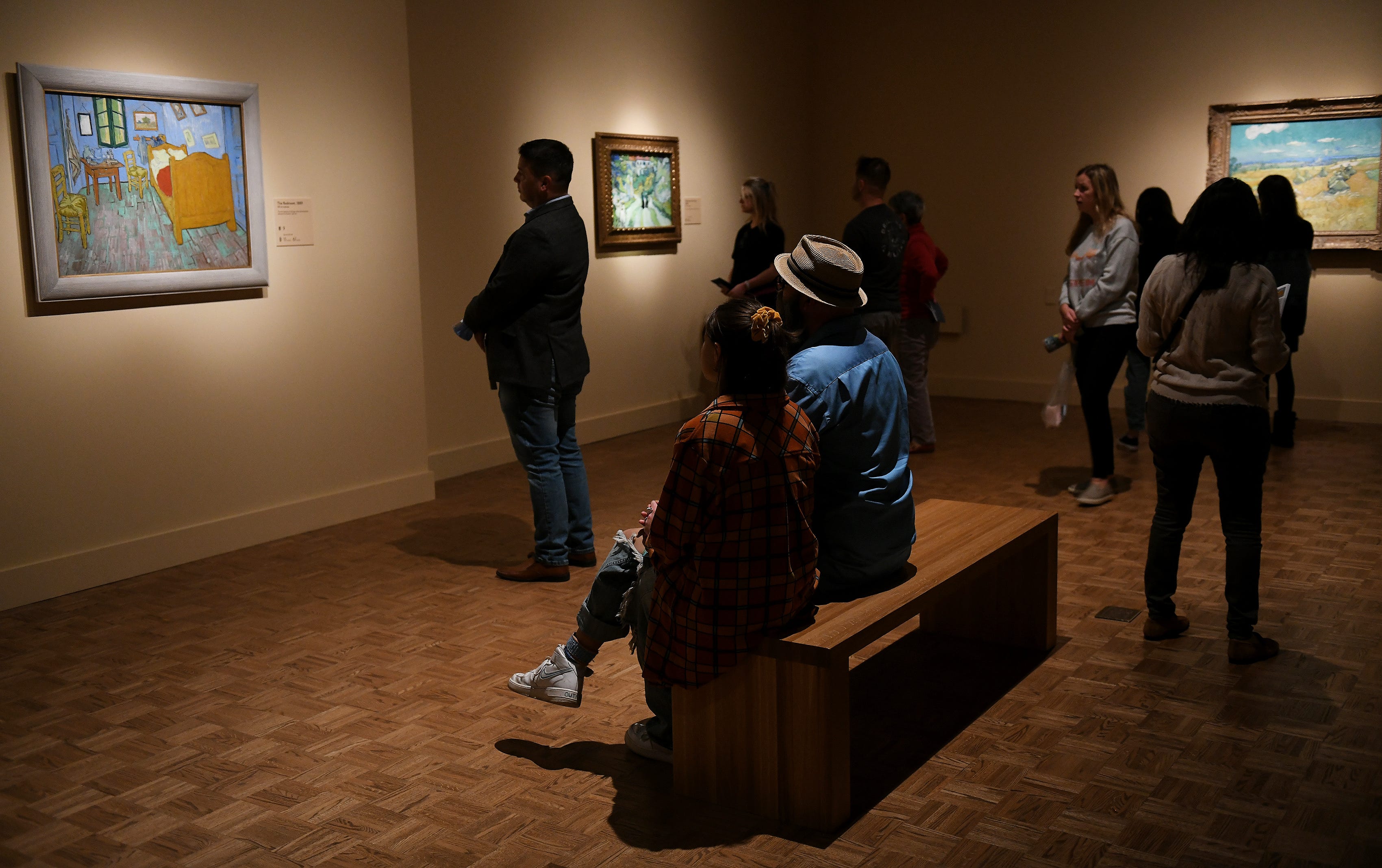People look at “The Bedroom” at left and other paintings at the Van Gogh exhibit at the Detroit Institute of Arts in Detroit on Oct. 2, 2022.