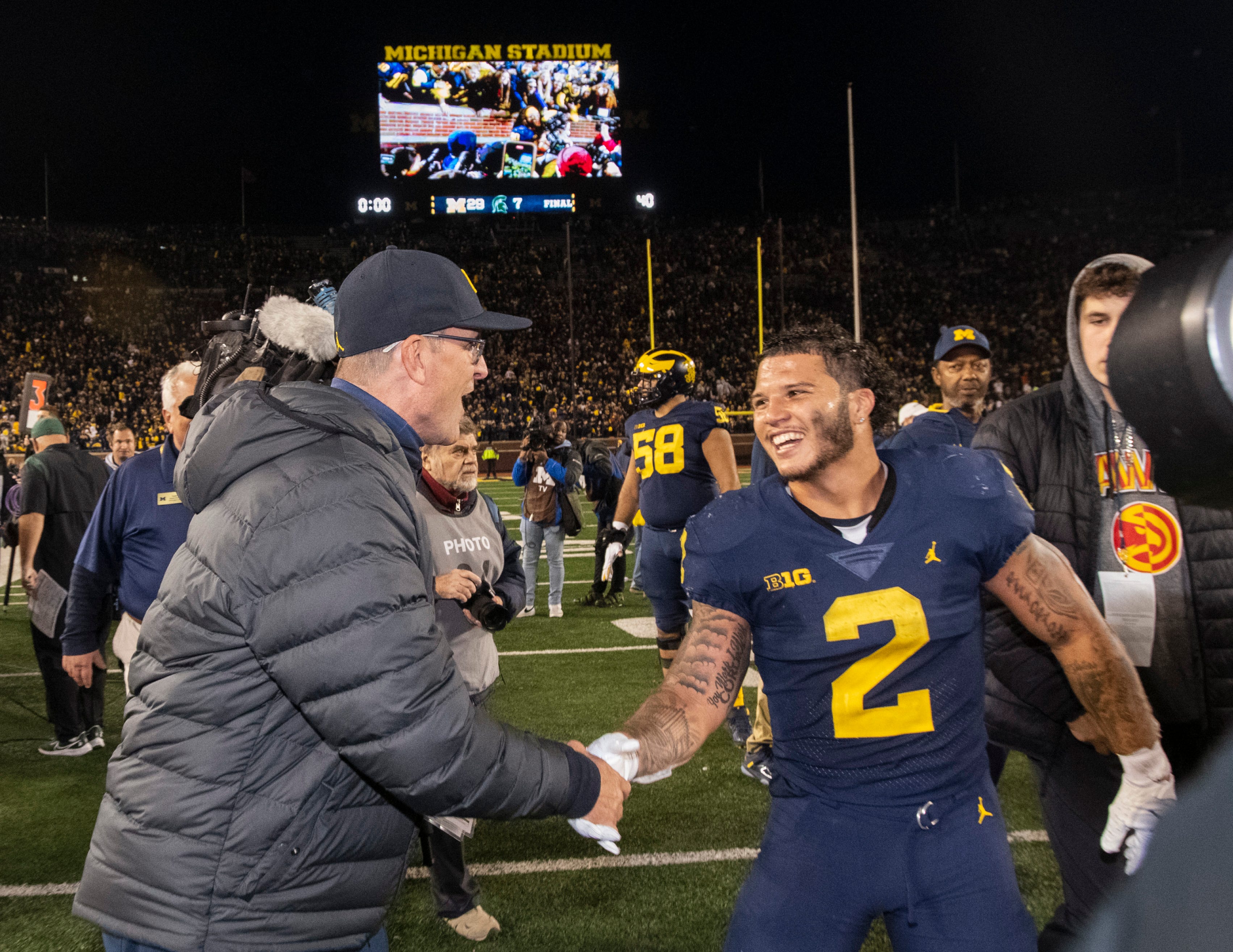 Michigan running back Blake Corum is all smiles as he greets head coach Jim Harbaugh on the field immediately after Michigan’s 29-7 victory over Michigan State in Ann Arbor.  Corum rushed for 177 yards and two touchdowns. The fourth-ranked and still-undefeated Michigan Wolverines (8-0) avenged last year’s loss to the Spartans in East Lansing with a dominant defensive performance.