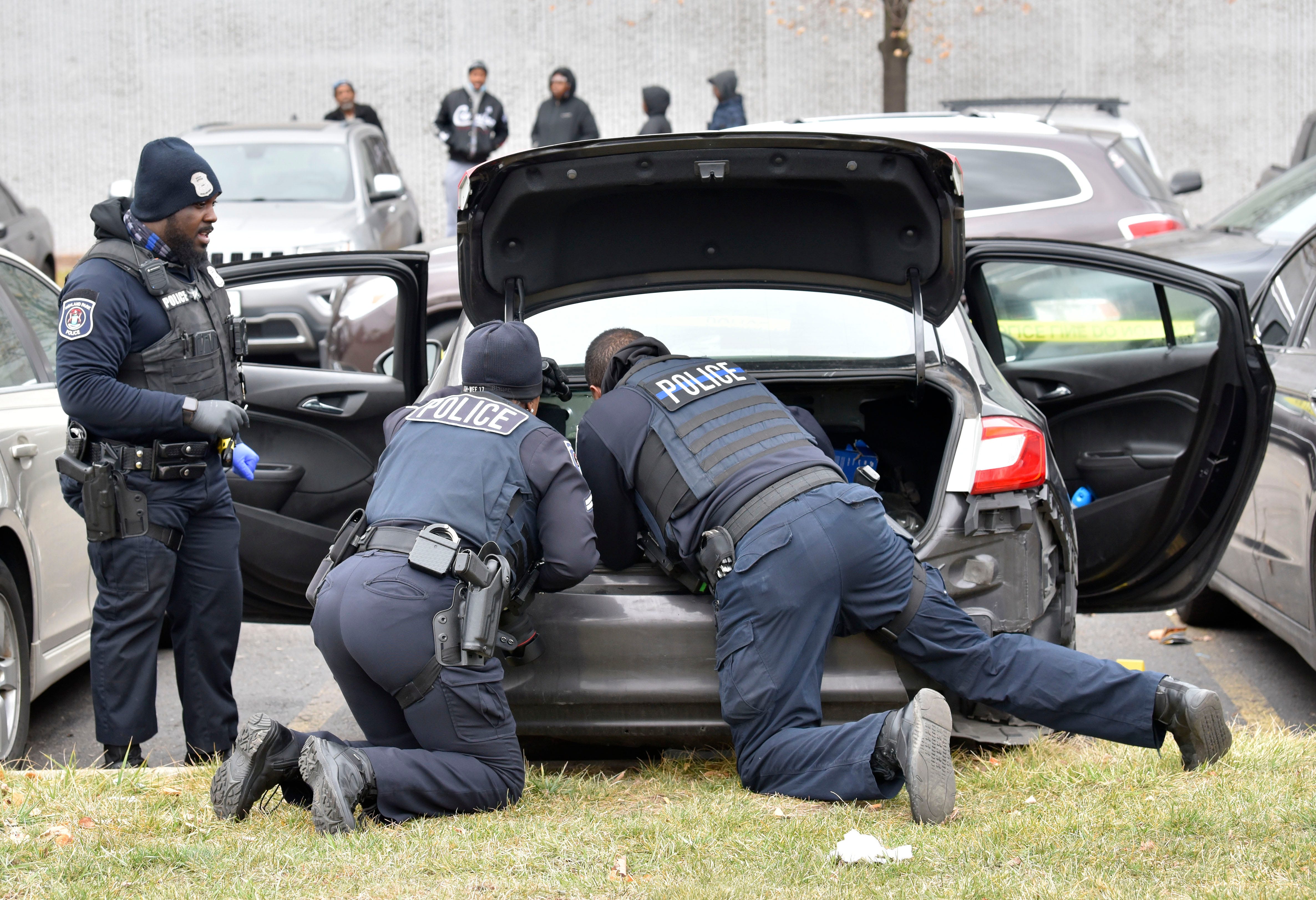 Highland Park police officers look in the trunk of this vehicle at the scene of the shooting, Wednesday afternoon, December 14, 2022.