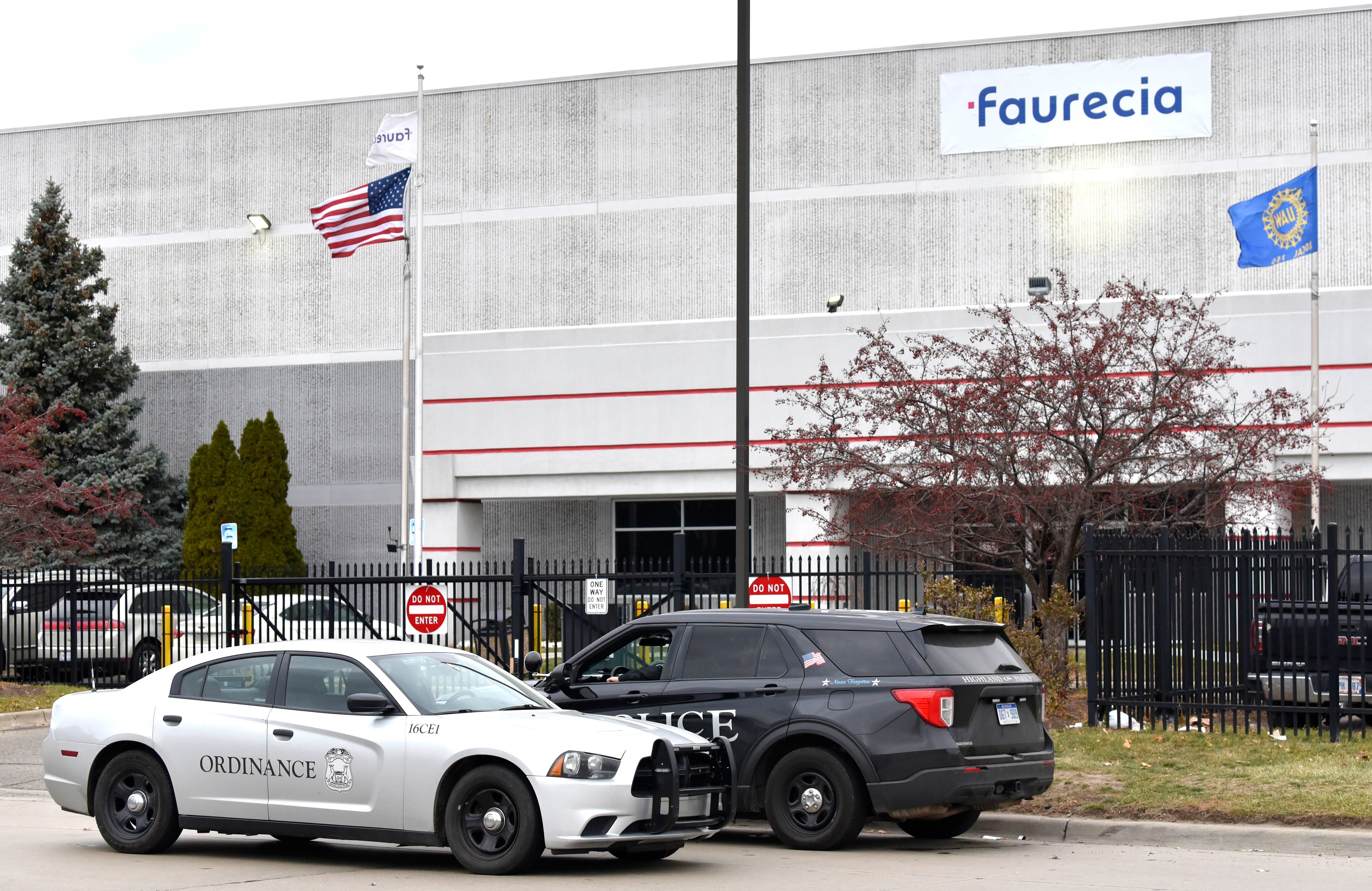 Highland Park police officers investigate the scene of a deadly shooting in the front parking lot of the Faurecia plant in Highland Park, Wednesday afternoon, December 14, 2022.
