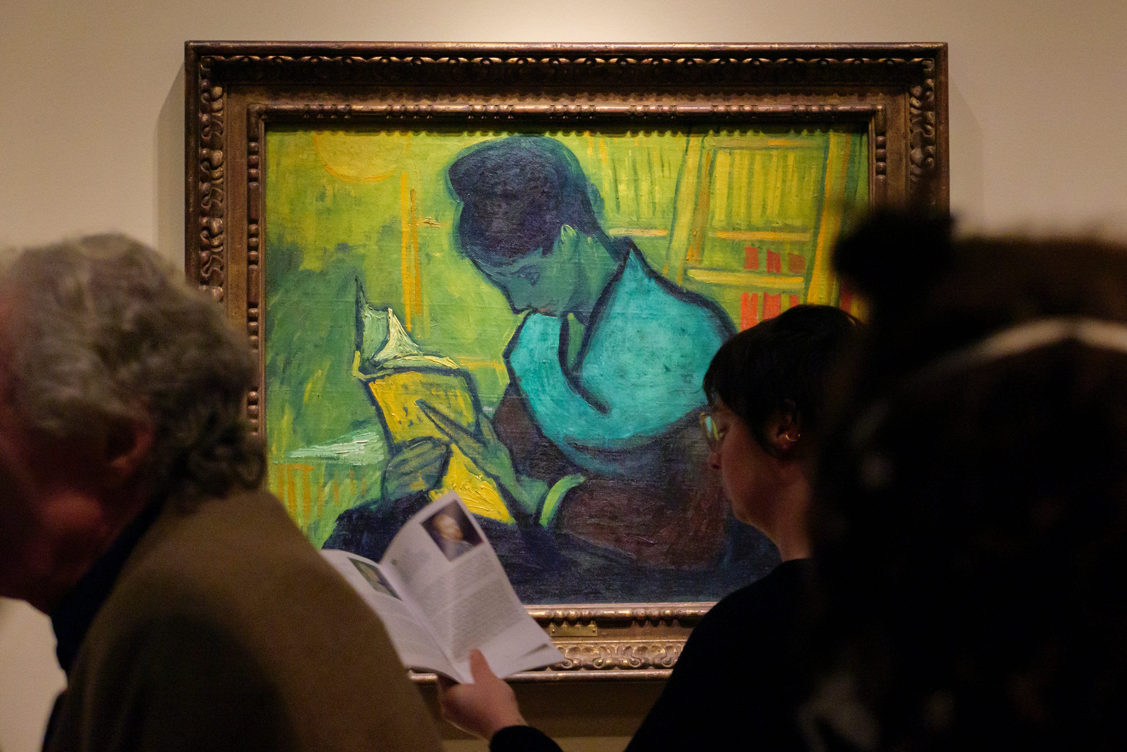 Visitors file past at the Van Gogh painting "Liseuse De Romans" - also known as "The Novel Reader", during the Van Gogh in America exhibit at the Detroit institute of Arts, Wednesday, Jan. 11, 2023. Brazilian art collector Gustavo Soter's art brokerage company, Brokerarte Capital Partners LLC, sued the DIA, describing an international hunt for a rare oil painting by the Dutch Post-Impressionist master.