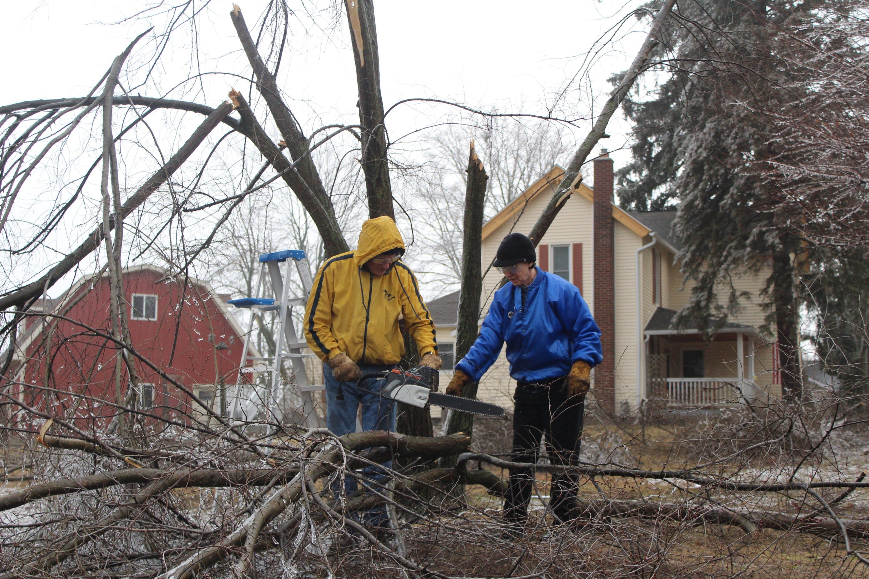 Philip and Madeleine Macy clean up their yard in Ypsilanti after a storm ripped through the surrounding trees, Feb. 23, 2023.