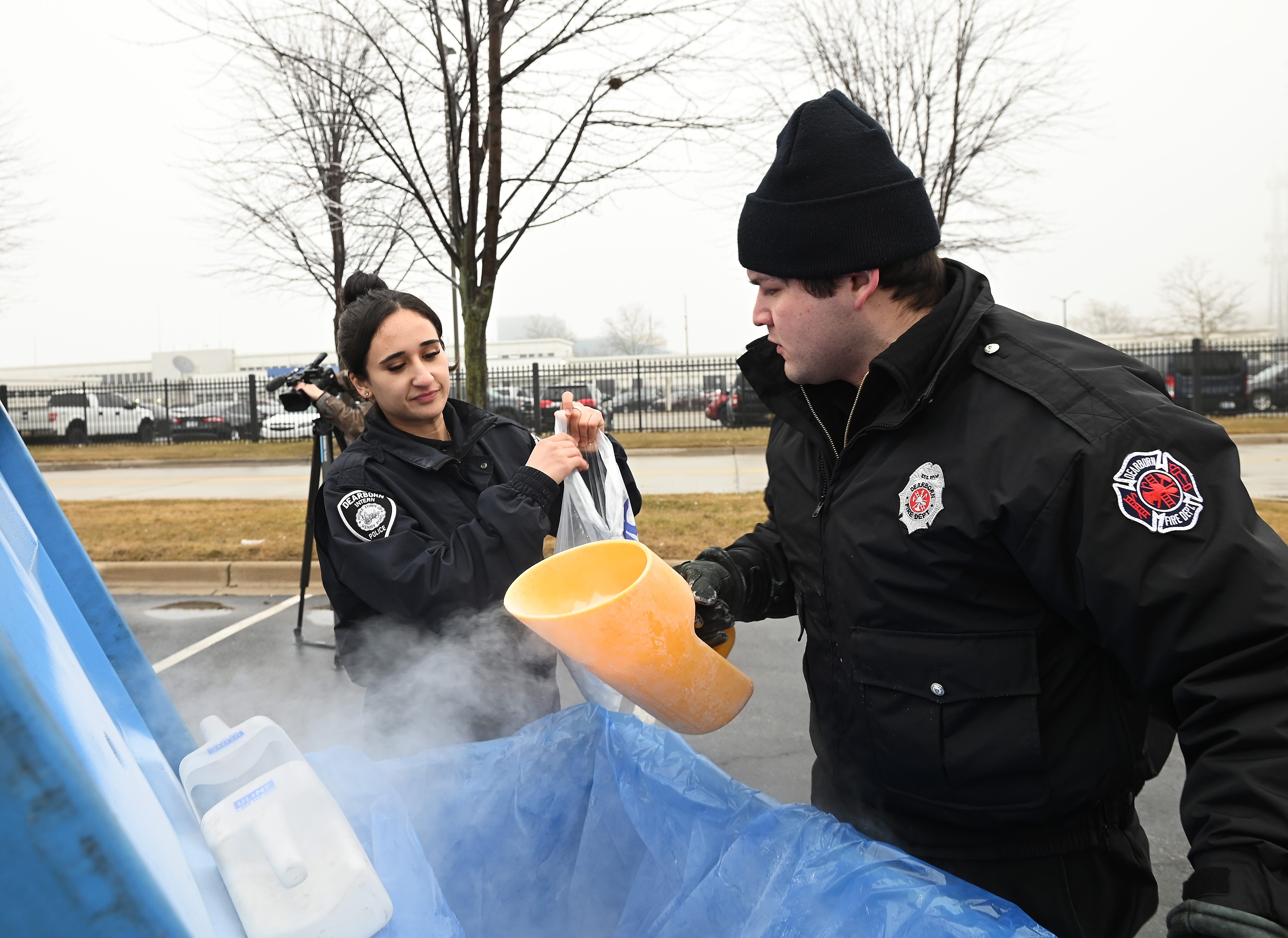 L-r, Dalal Abuhassan, 21, Police Intern of the City of Dearborn and Joey Herrera, 25, Fire Dept. Intern, packs bags of dry ice for residents during the free give away by the City of Dearborn to help residents affected by the ice storm. February 23, 2023, Dearborn, MI.