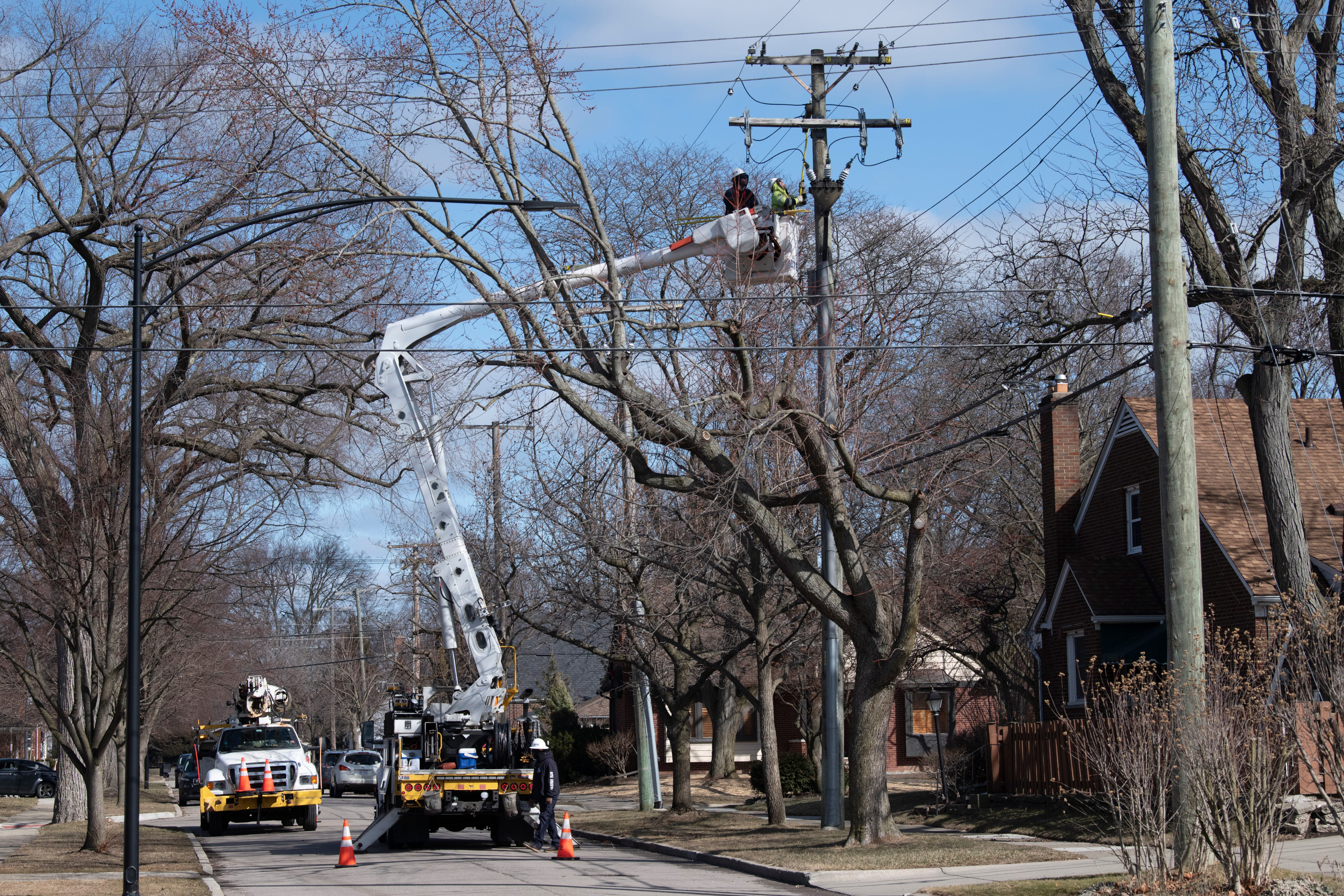 DTE servicemen work on Piche Street near Kerby Road in Grosse Pointe Woods to restore electricity to  the neighborhood Friday afternoon, February 24, 2023, after a midweek winter storm coated the area with freezing rain knocking out power to thousands of homes and businesses.
