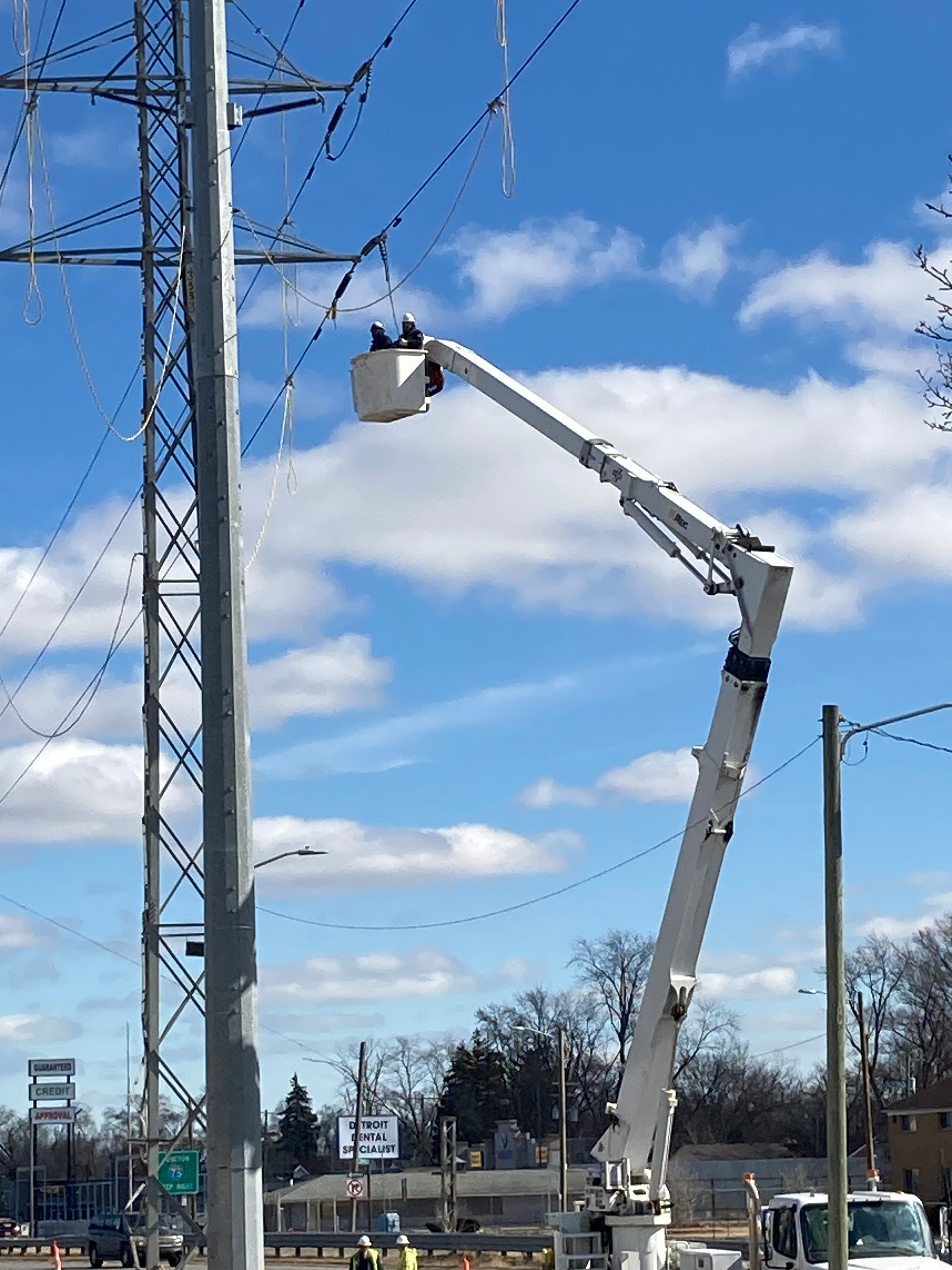 Electrical repair workers in an altec cherry picker work on a high tension line along 8 Mile near Hazel Park.