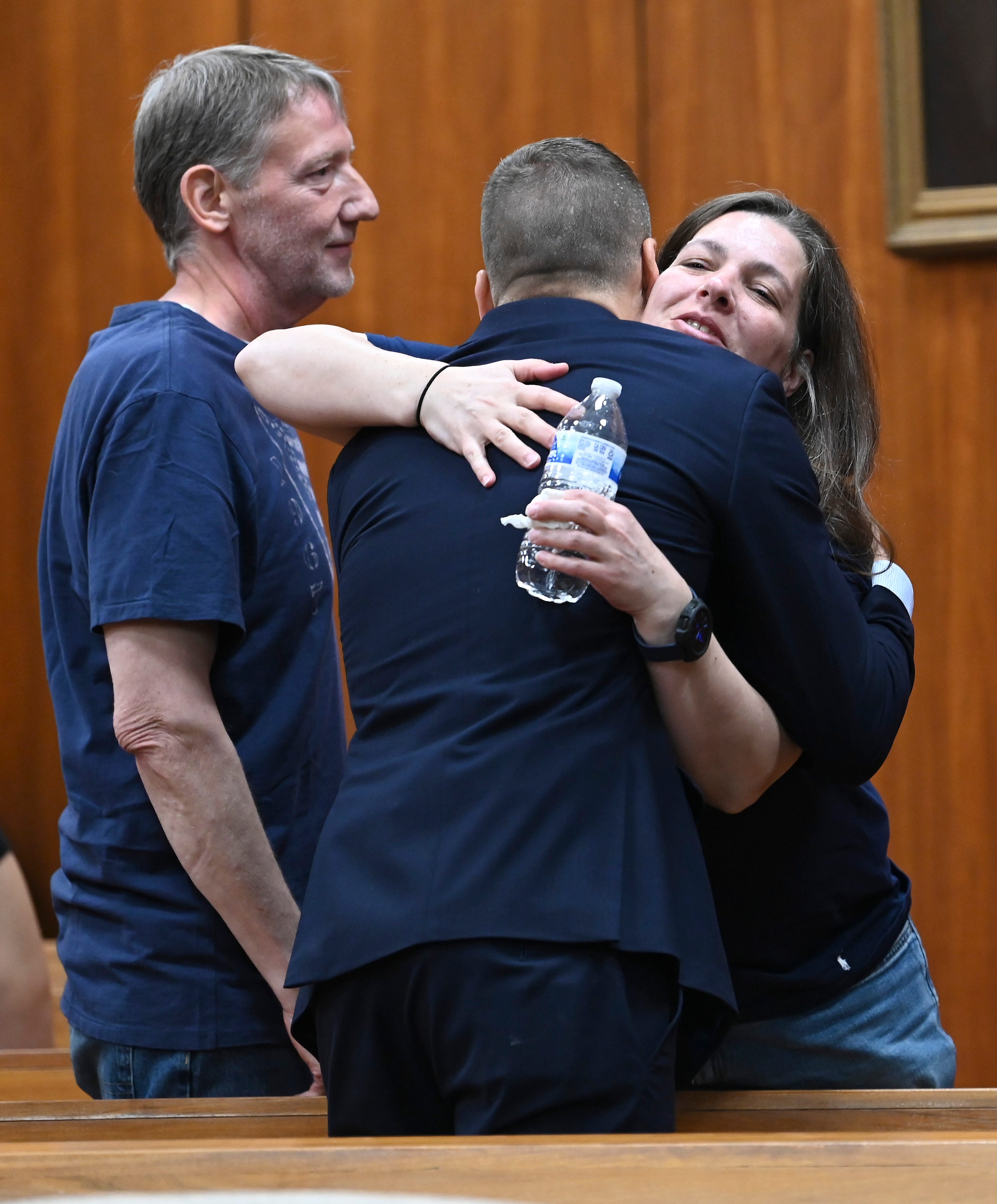 Jennifer Nicolai, right, sister-in-law to victim Jim Nicolai, hugs Macomb County Assistant Prosecuting Attorney Steve Fox, center, as Jim’s brother, Joe Nicolai, left, stands by after sentencing, Thursday, June 1, 2023.