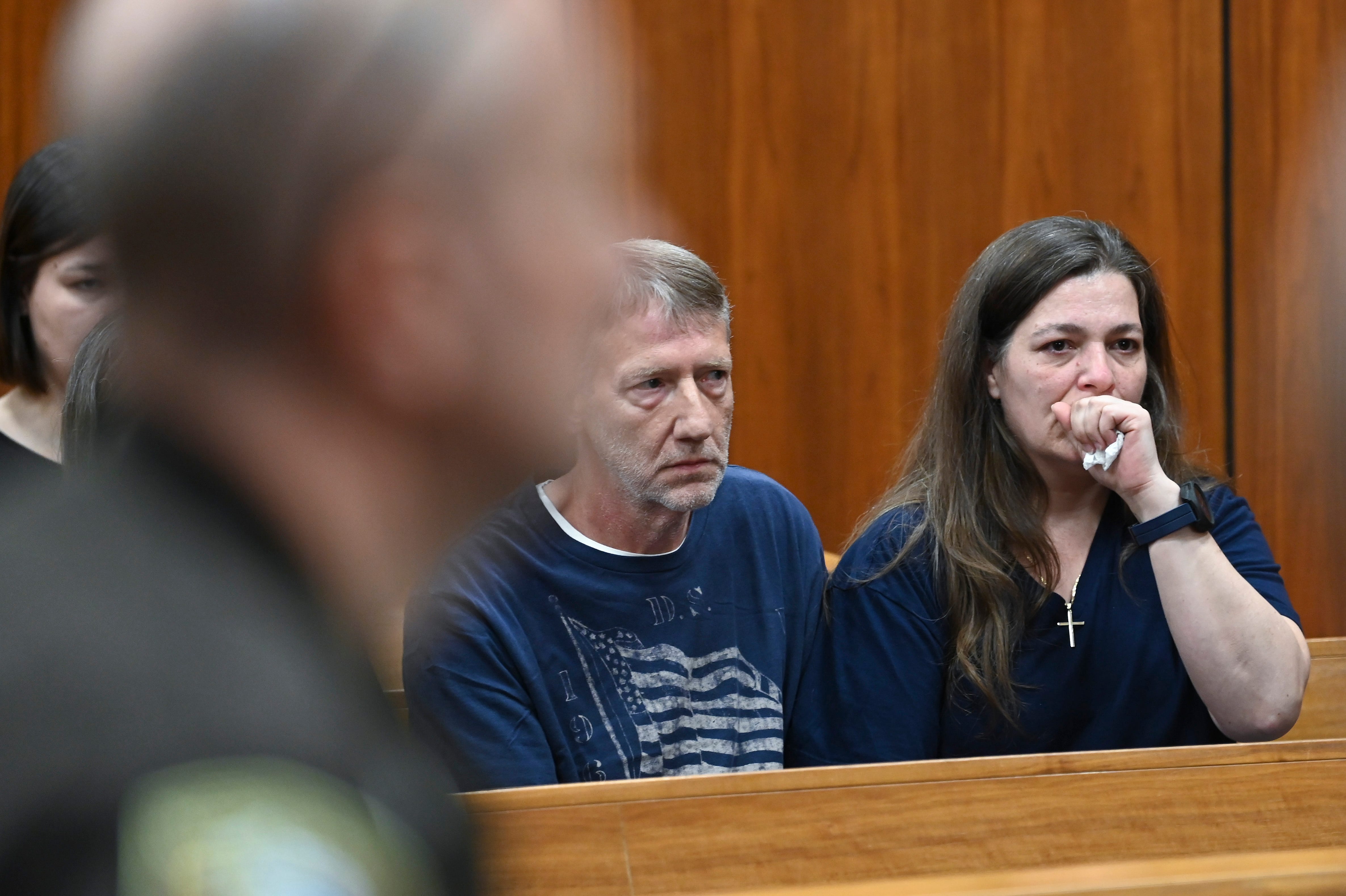 Macomb County Sheriff’s deputies stand by as Joe Nicolai, left, brother to victim Jim Nicolai and Joe’s wife, Jennifer, right, watch a video, Thursday, June 1, 2023.